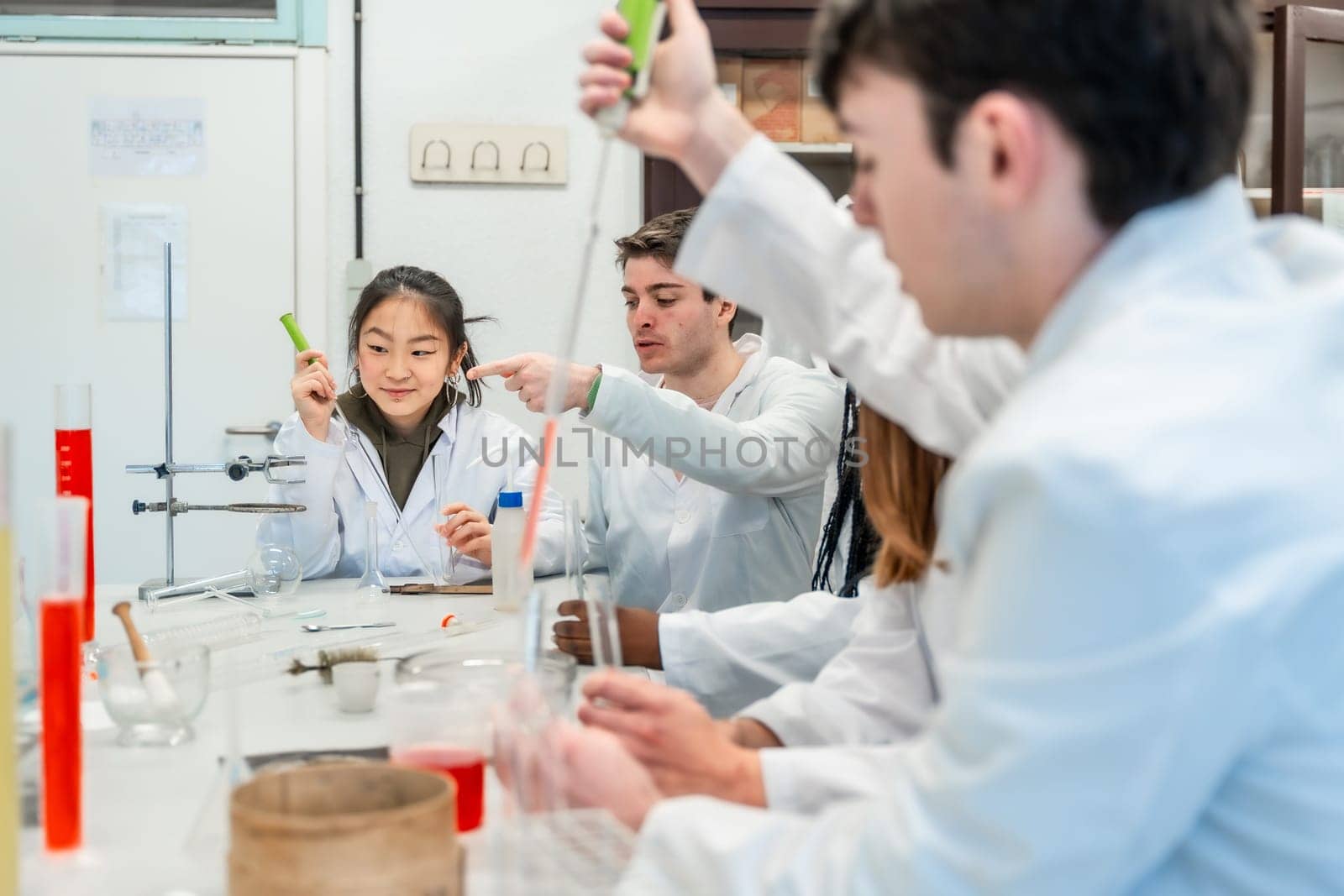 University students in lab coats conducting a chemistry experiment, collaborating and learning together