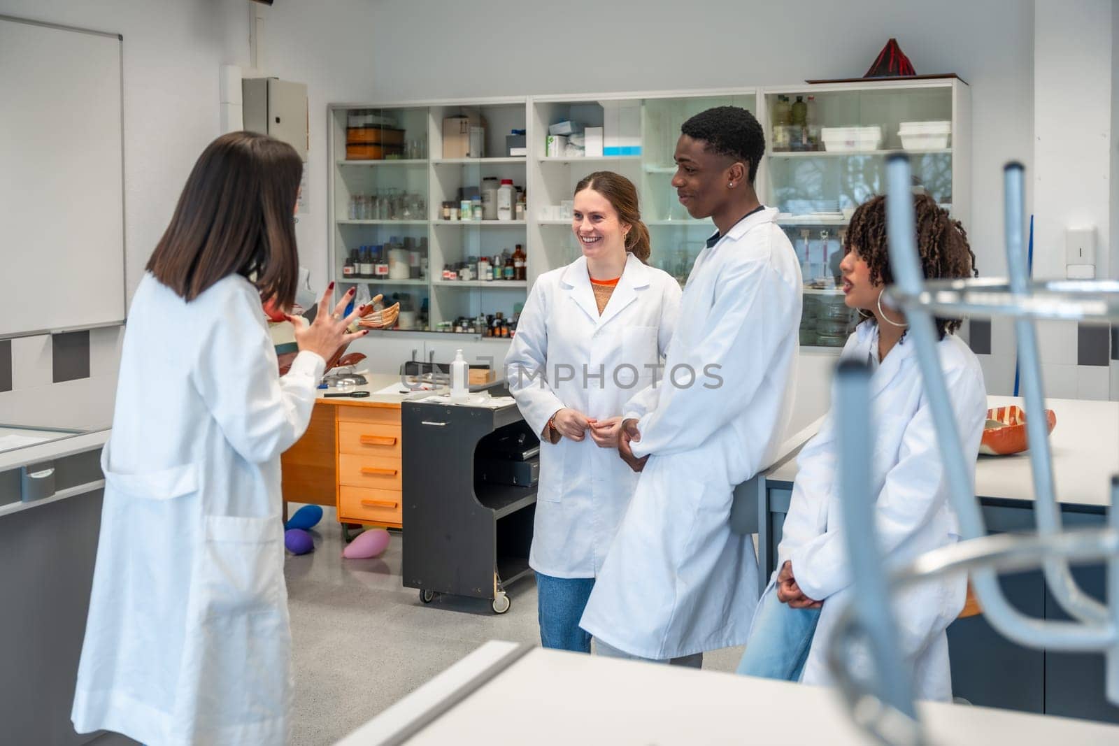 Group of multi ethnic medical students listening to their teacher explaining human anatomy in a university laboratory