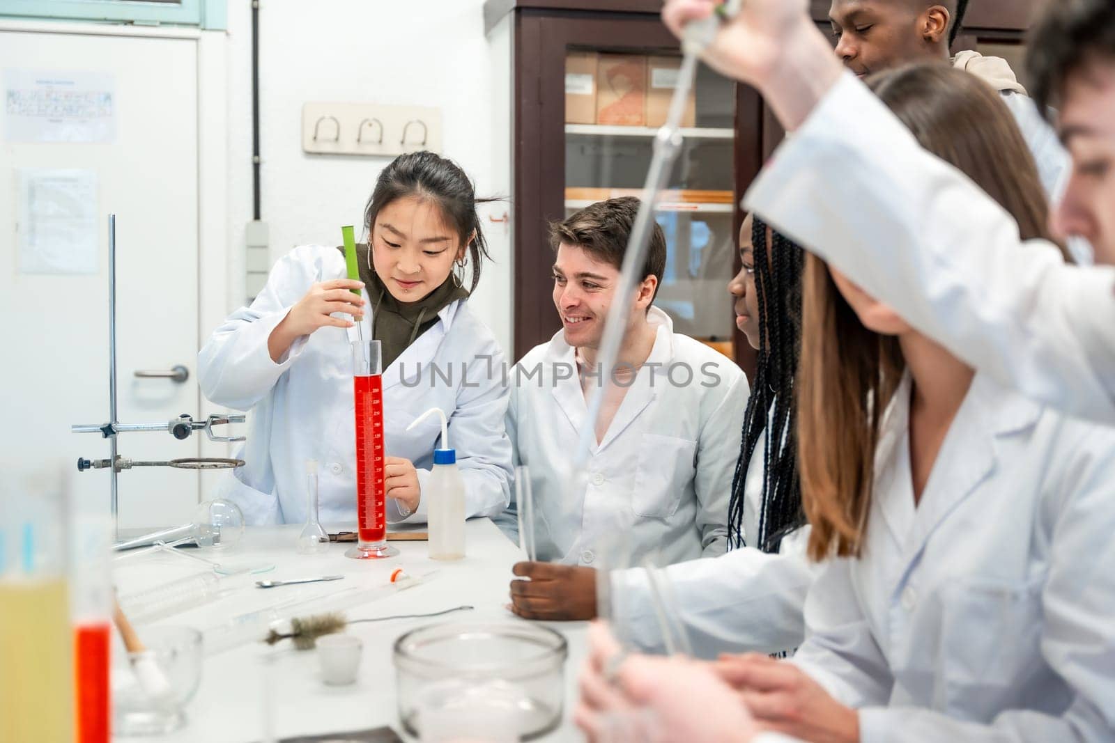 Diverse group of university chemistry students conducting an experiment in a laboratory, demonstrating teamwork and scientific inquiry