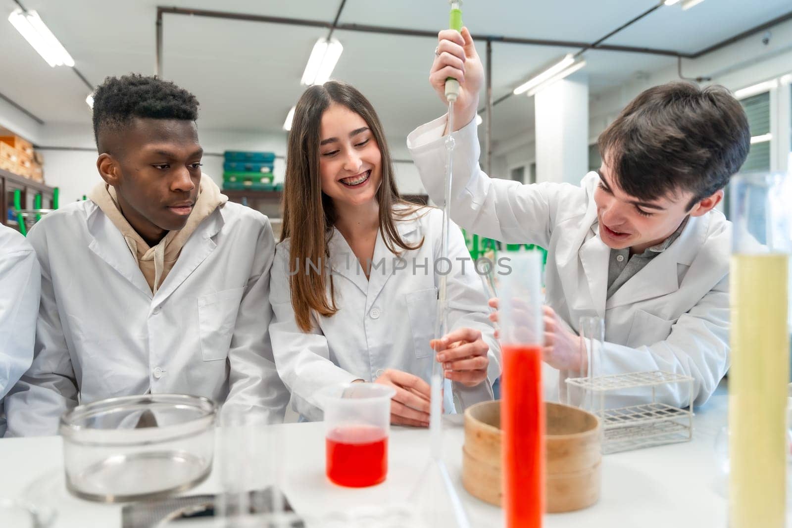 University students in lab coats conducting a chemistry experiment, using lab equipment and chemicals, demonstrating teamwork and scientific inquiry