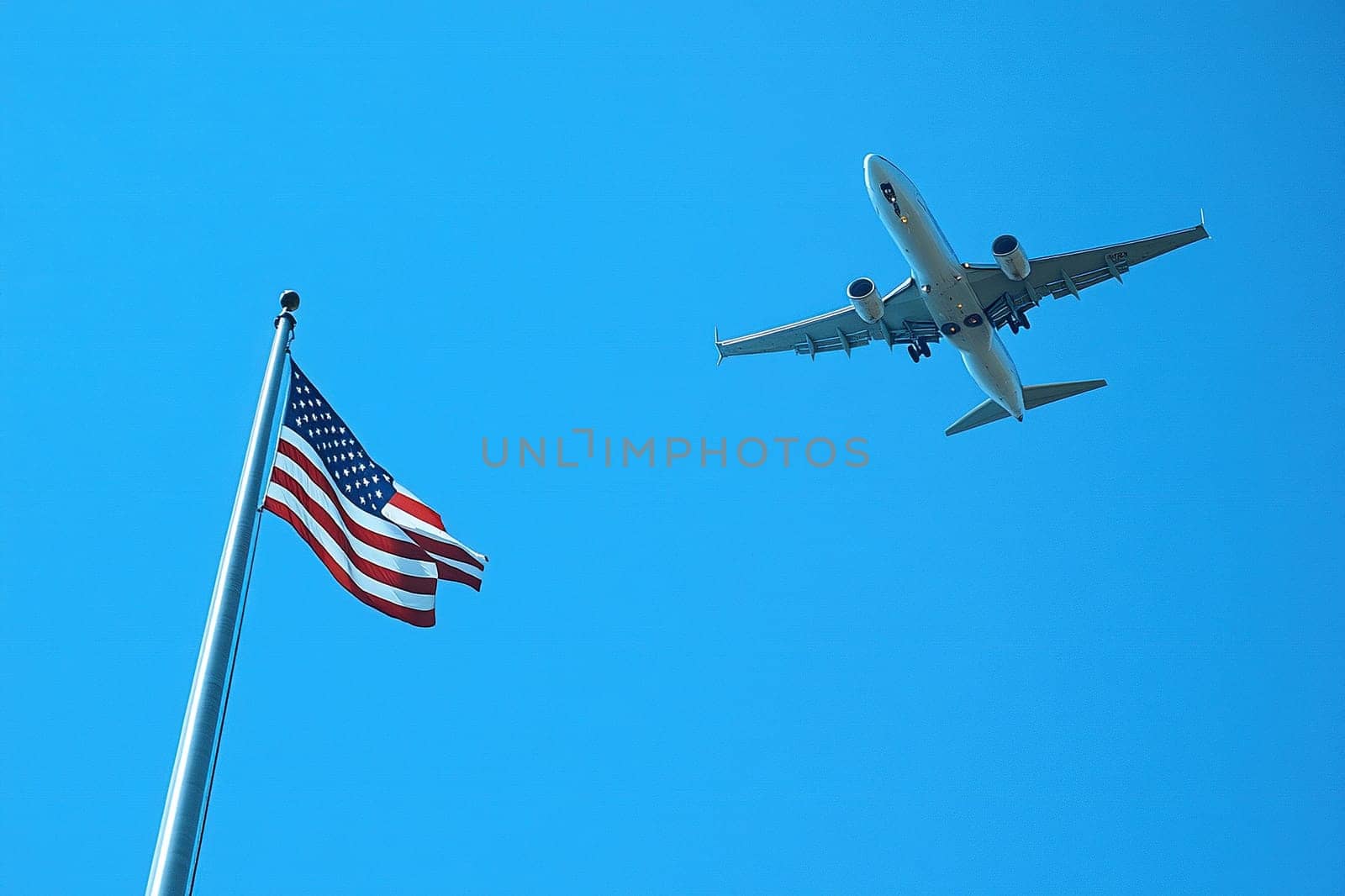 Bottom view of a passenger plane in the blue sky flying over the US flag.