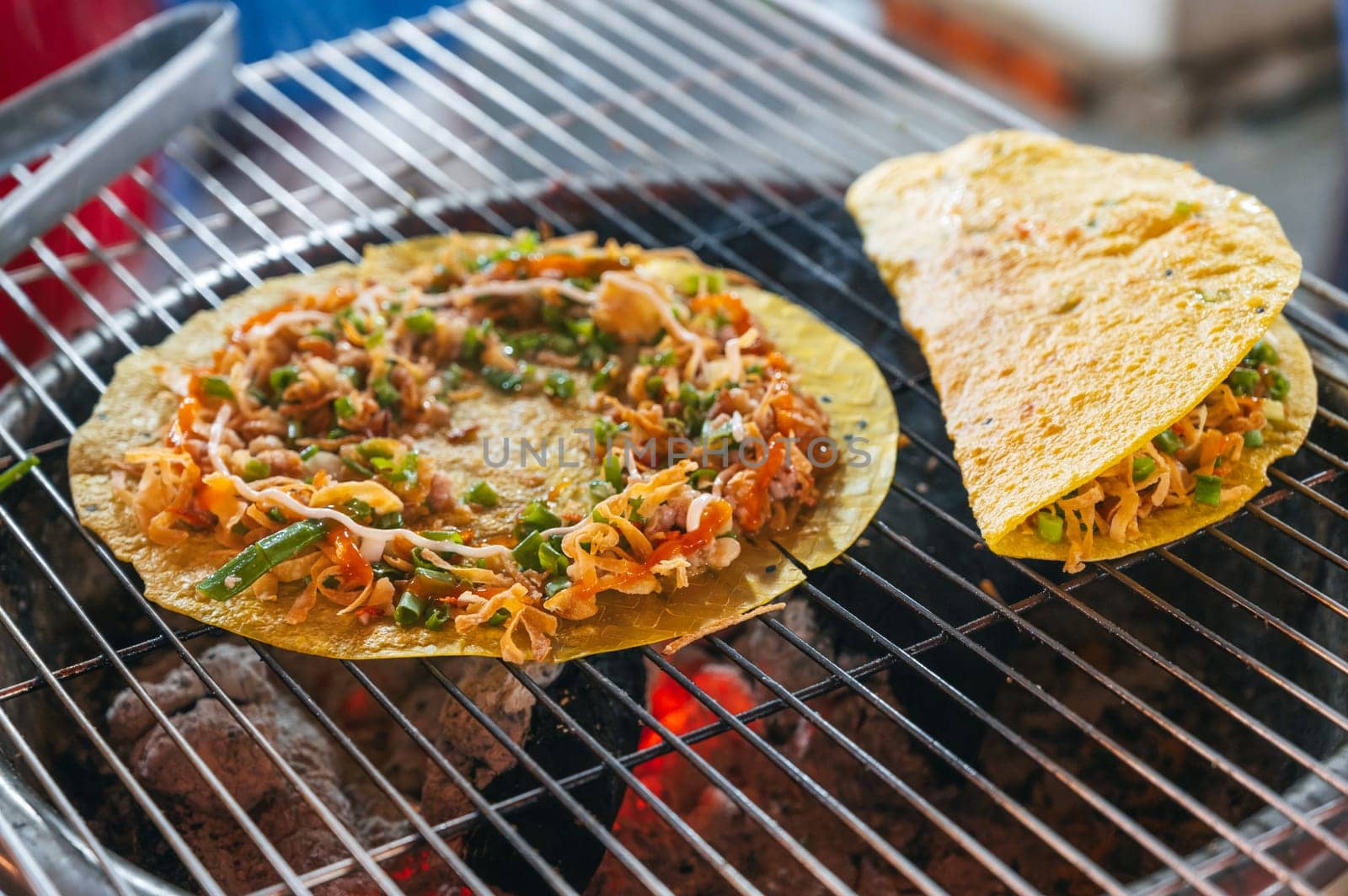 Vietnamese banh Xeo pancakes grilled at an Asian street night market in Vietnam. Traditional Vietnamese street food
