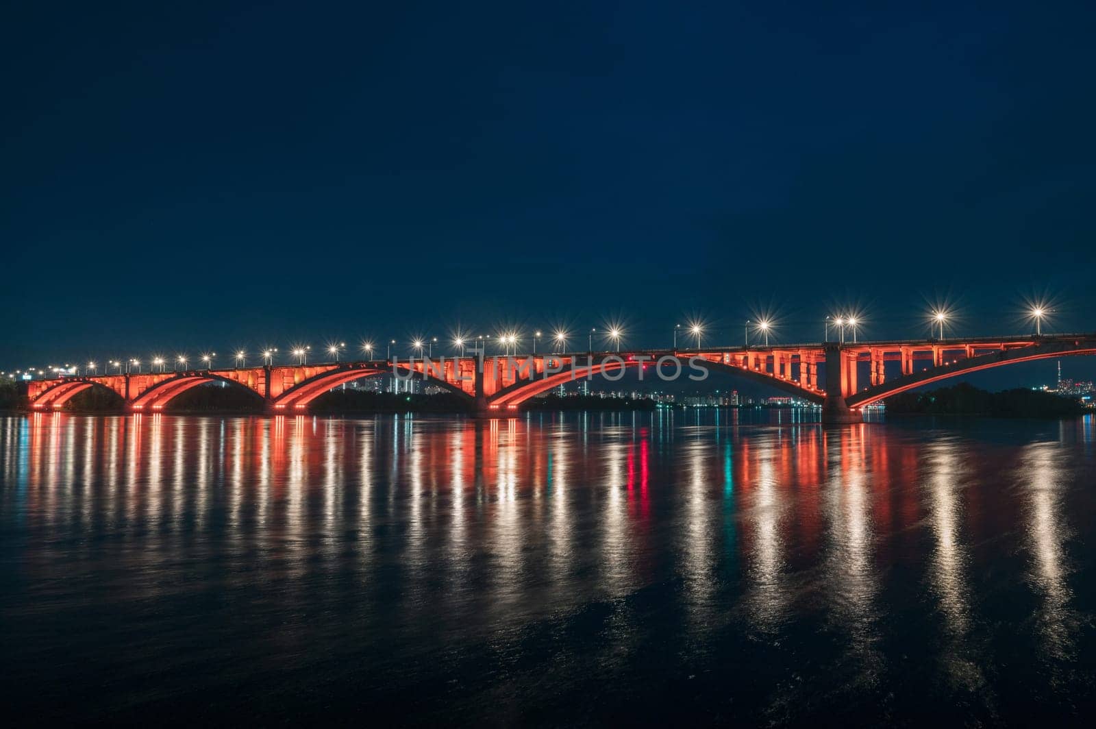 Night view of the famous Communal bridge in Krasnoyarsk through the Yenisei River in Russia, Krasnoyarsk. This bridge is depicted on the 100 rouble bill