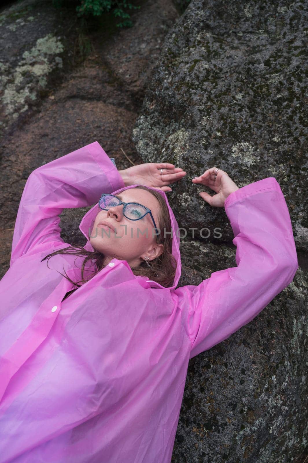 Portrait of woman in the raincoat the taiga forest and rocks of the Stolby nature reserve park, Krasnoyarsk, Russia