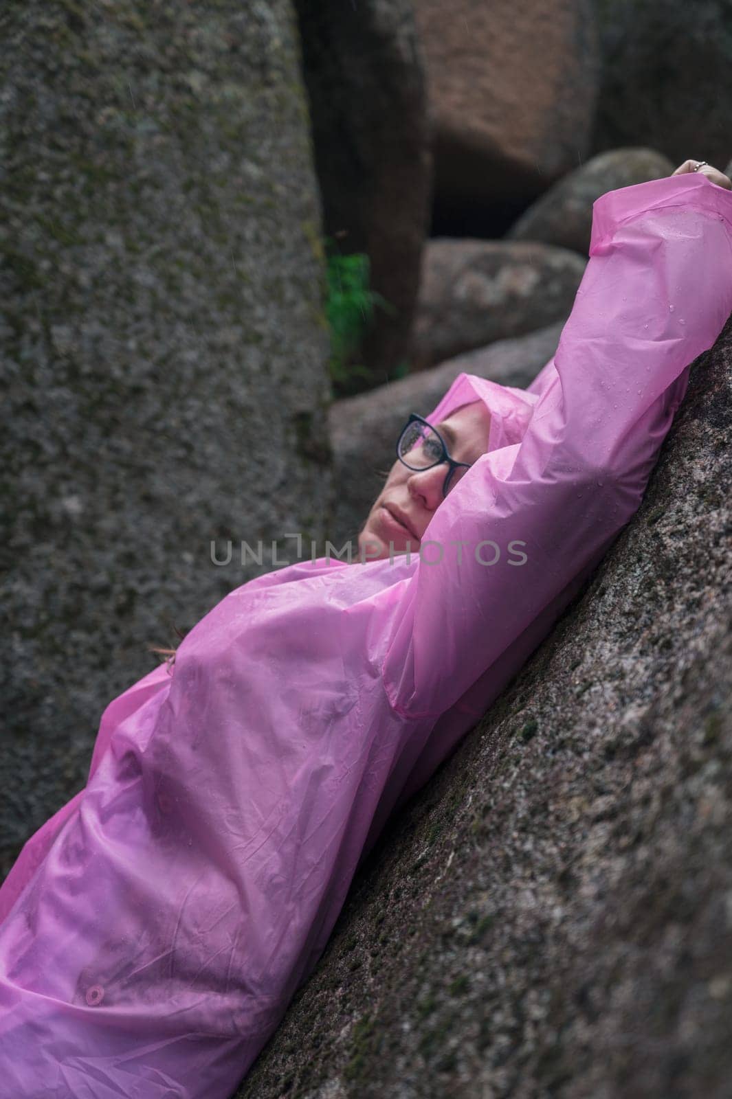 Portrait of woman in the raincoat the taiga forest and rocks of the Stolby nature reserve park, Krasnoyarsk, Russia