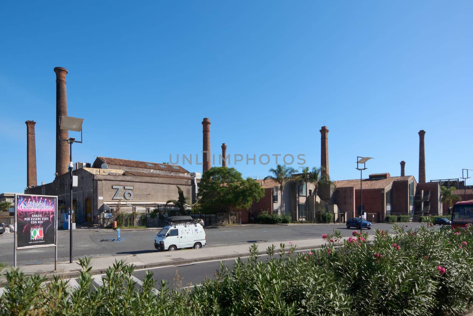 Catania. Italy - February 25, 2025: Industrial area with an old brick building and multiple tall chimneys, reflecting urban decay and historical significance. Concept: industrial heritage, urban decay