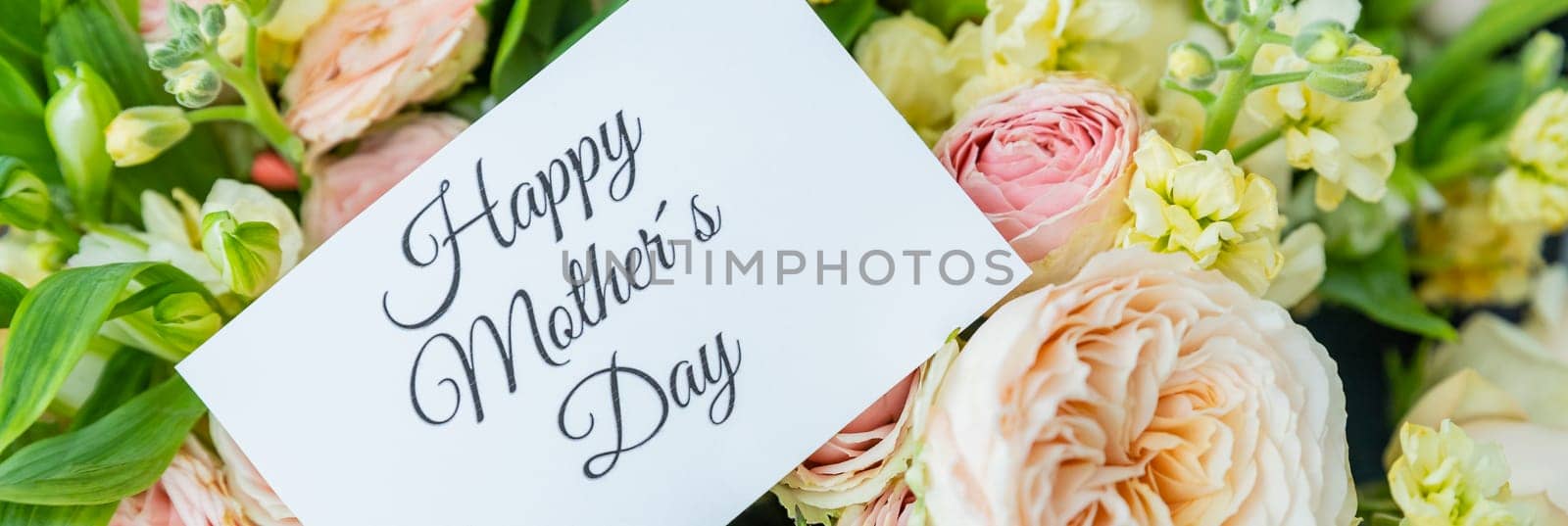 Amazing tender bouquet with pink ranunculus, violet Alstroemeria flowers and tiny white roses in cardboard box with pink ribbon. Beautiful bunch of spring flowers. Easter gift. Seasonal spring flowers