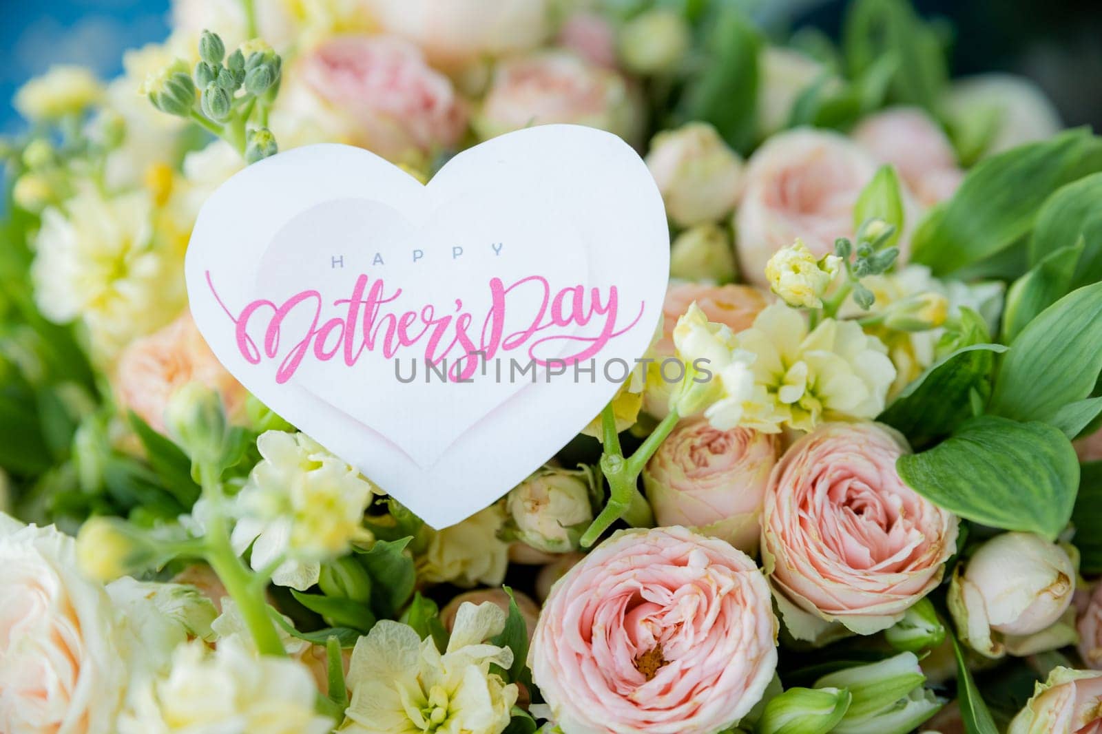 Amazing tender bouquet with pink ranunculus, violet Alstroemeria flowers and tiny white roses in cardboard box with pink ribbon. Beautiful bunch of spring flowers. Easter gift. Seasonal spring flowers