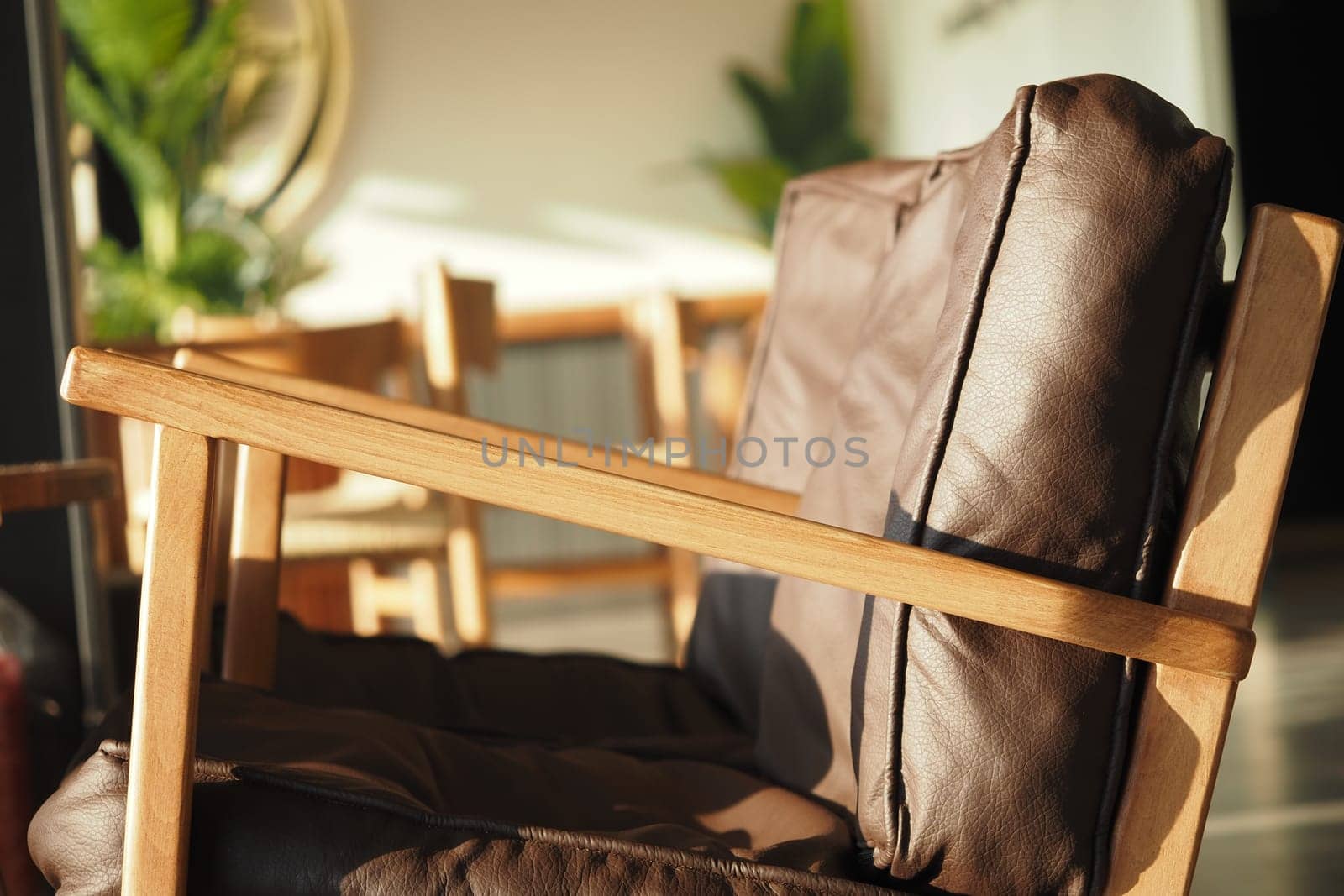 A cozy space features a wooden chair with a leather cushion.