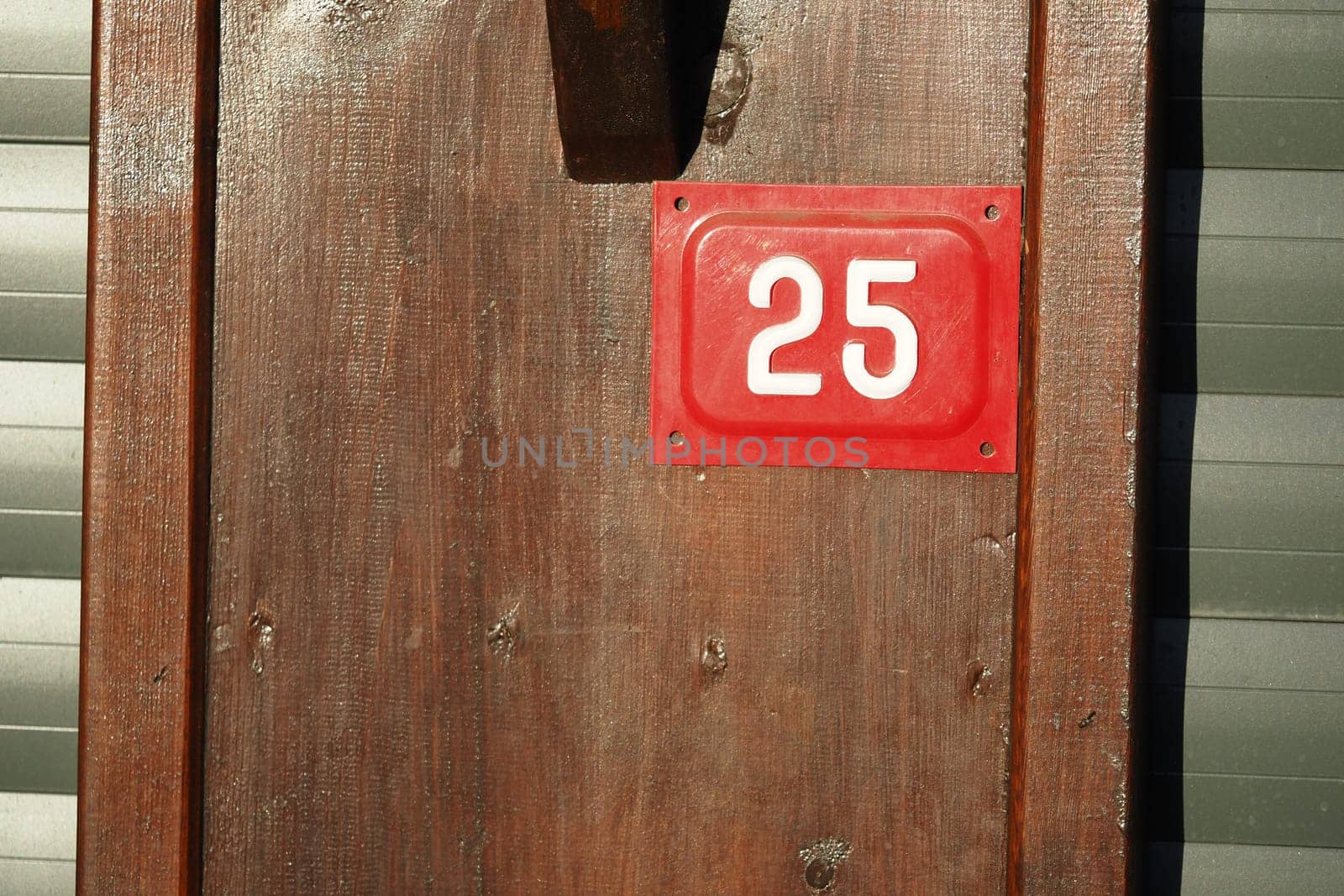 House number 25 is clearly visible on weathered wood at midday.