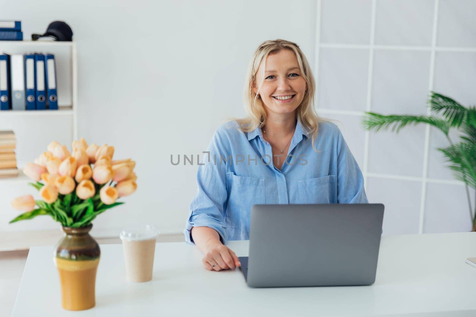 woman blonde working with laptop online in office