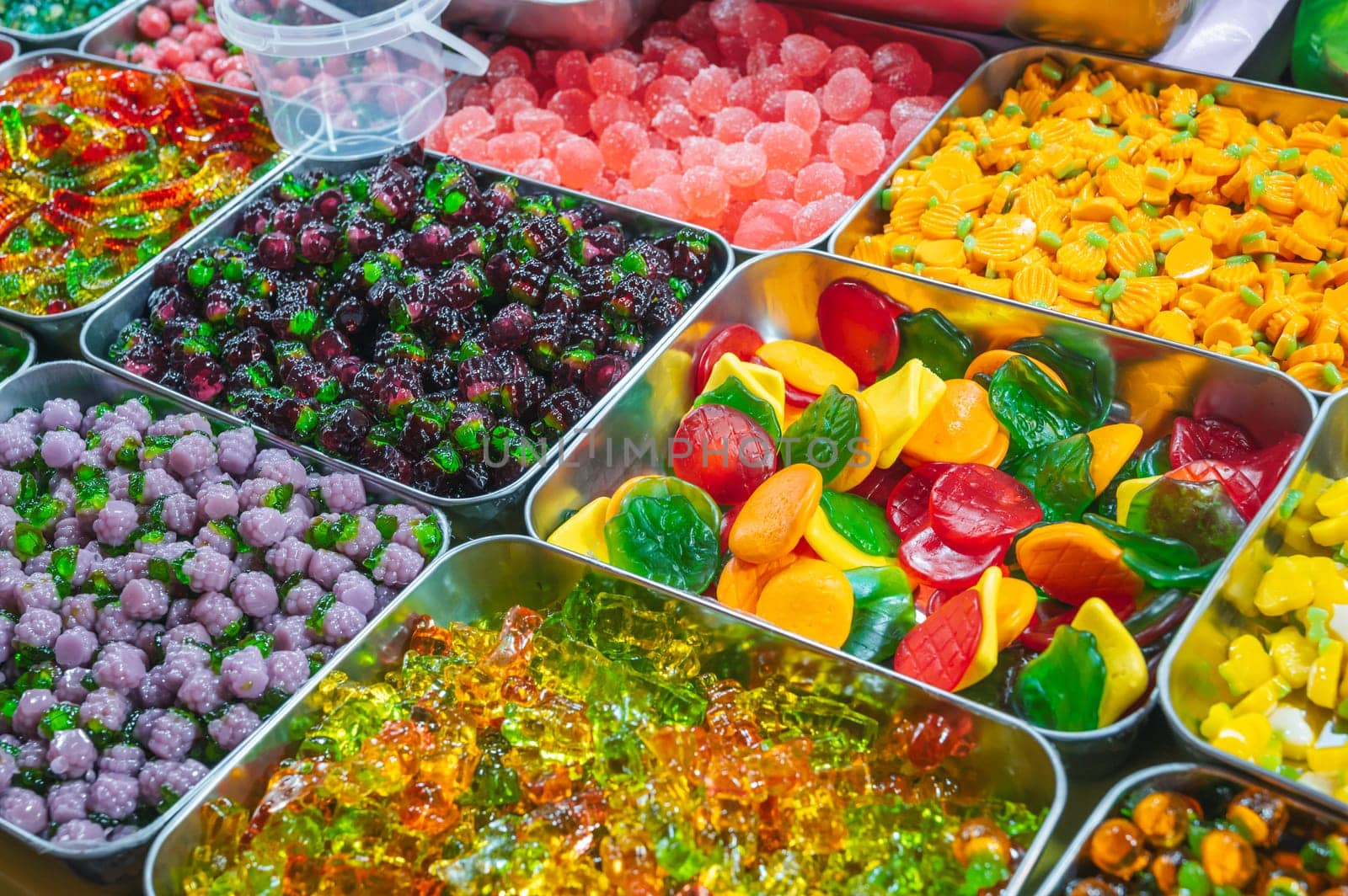 assorted colorful bright marmalade and chewable candies on the counter in the store