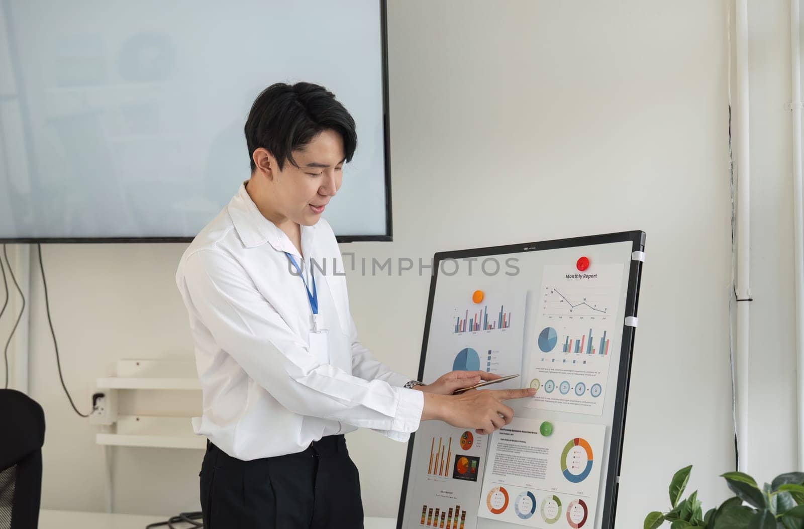 A young professional presents financial graphs and data, emphasizing teamwork and effective communication.