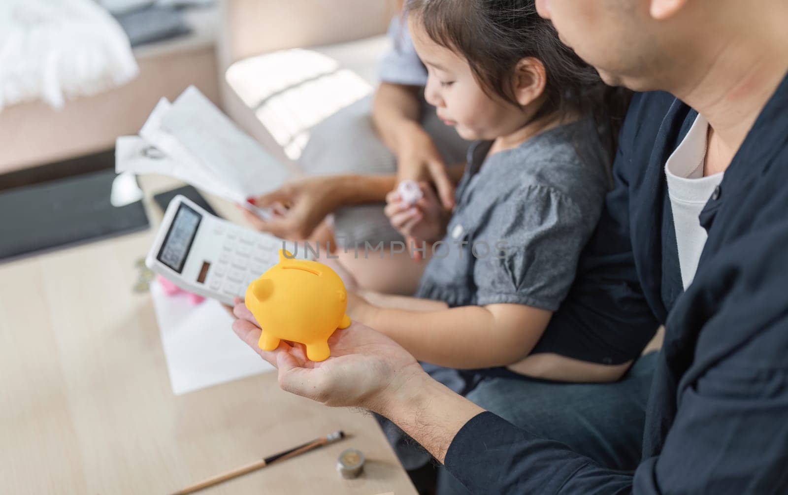 A family member holds a piggy bank during a budgeting session, emphasizing the importance of savings and financial planning.