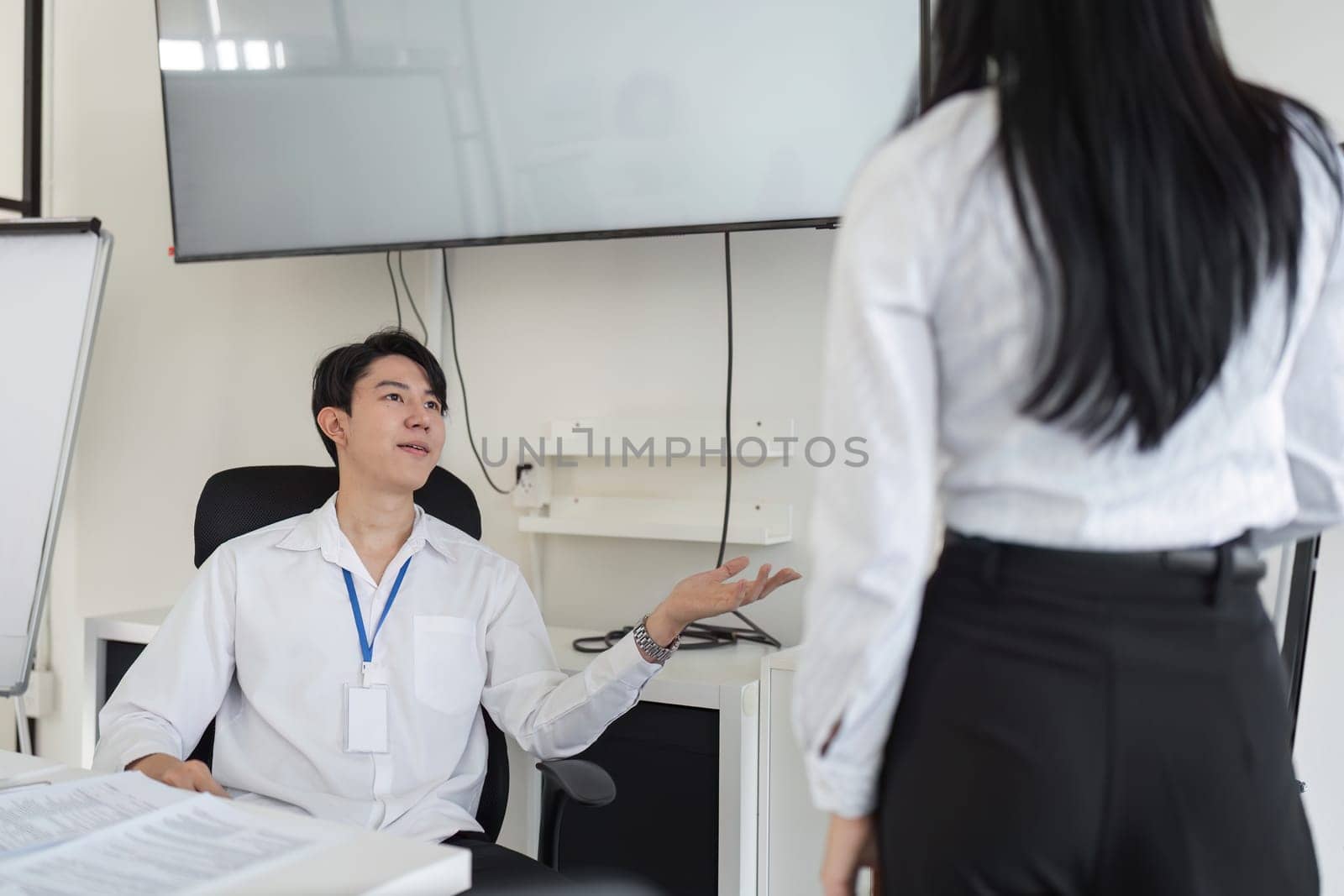 A tax consultant engages in a discussion about financial strategies with a colleague in a contemporary office environment.