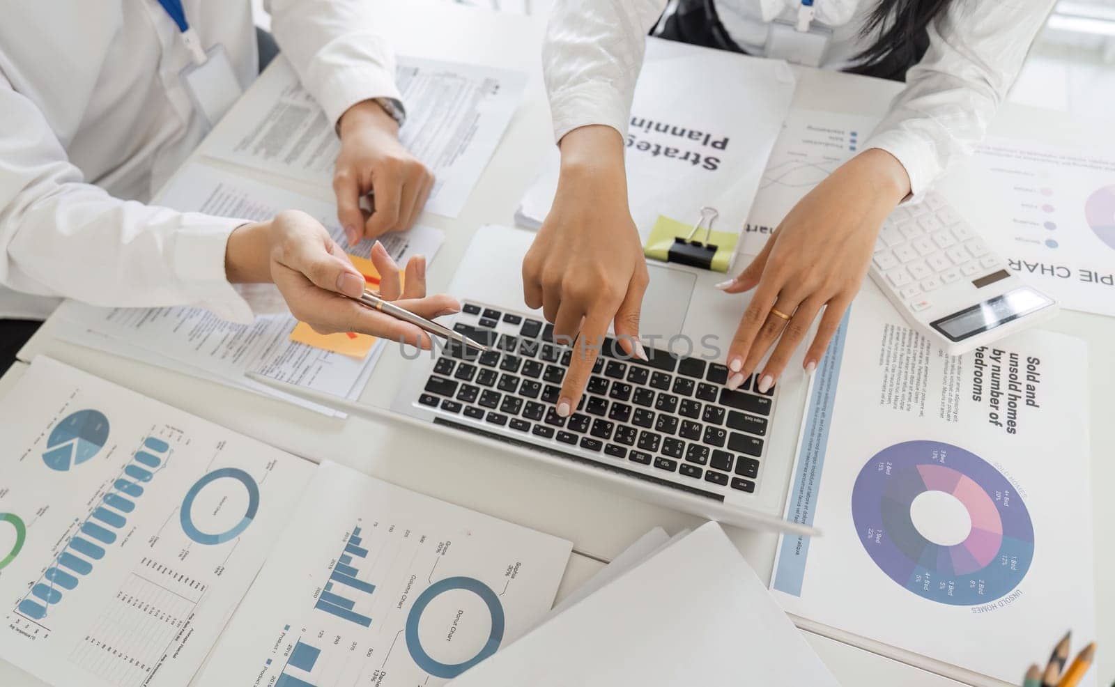 Professionals collaborate on tax strategies, analyzing data displayed on a laptop in a modern office setting.