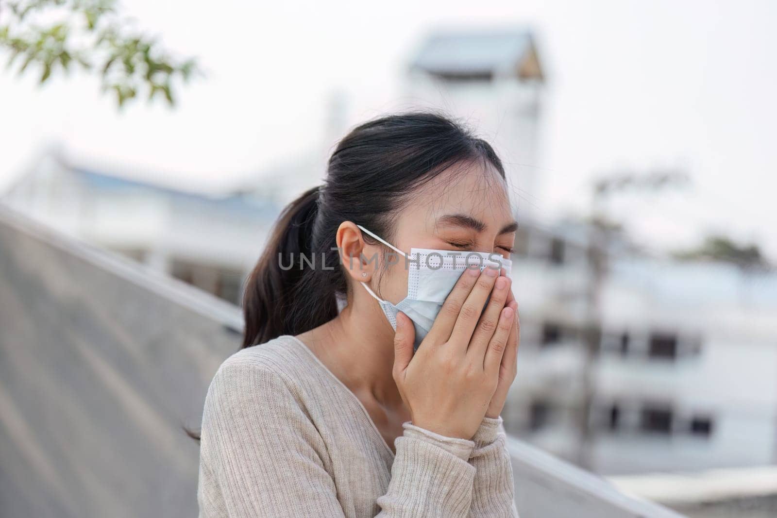 A woman puts on her mask while outdoors, highlighting the importance of health awareness in polluted environments.