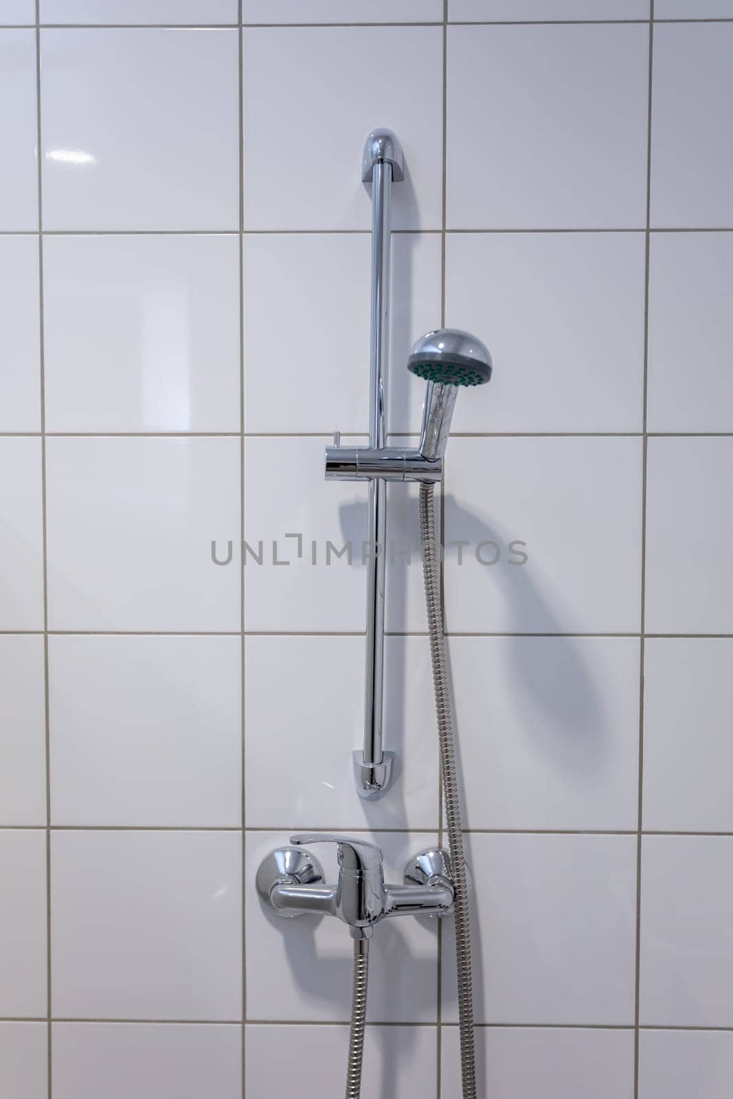 A stylish shower fixture securely mounted on beautifully tiled bathroom walls, perfect for modern interior designs