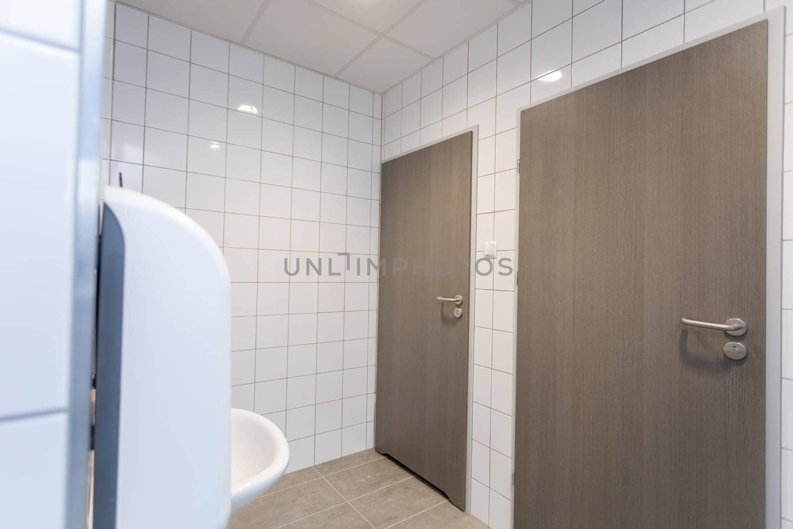 This contemporary restroom showcases elegant doors, sharp clean lines, and an overall minimalist decor that impresses