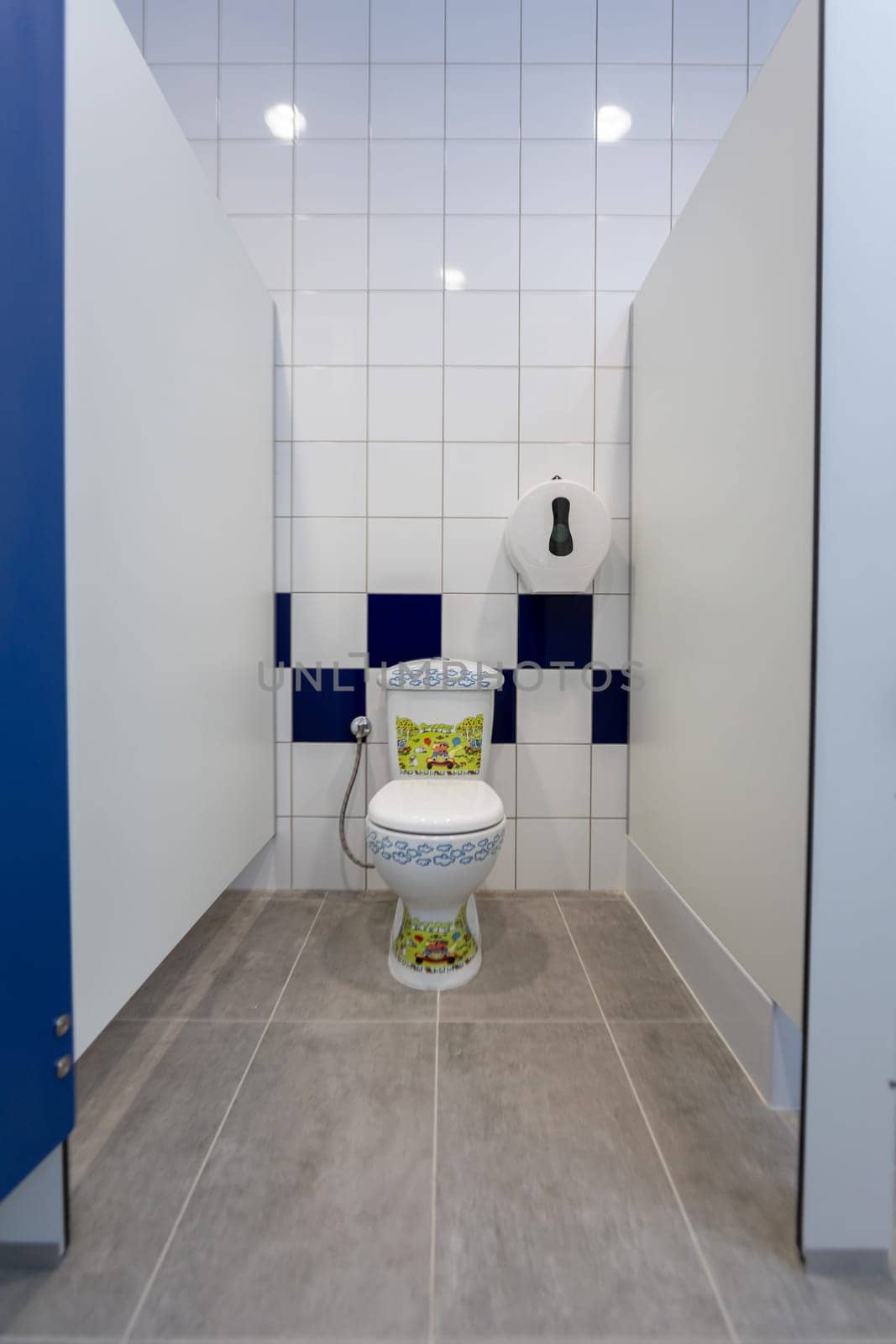 This is a modern toilet stall showcasing a vibrant, artistic toilet design complemented by sleek, clean lines
