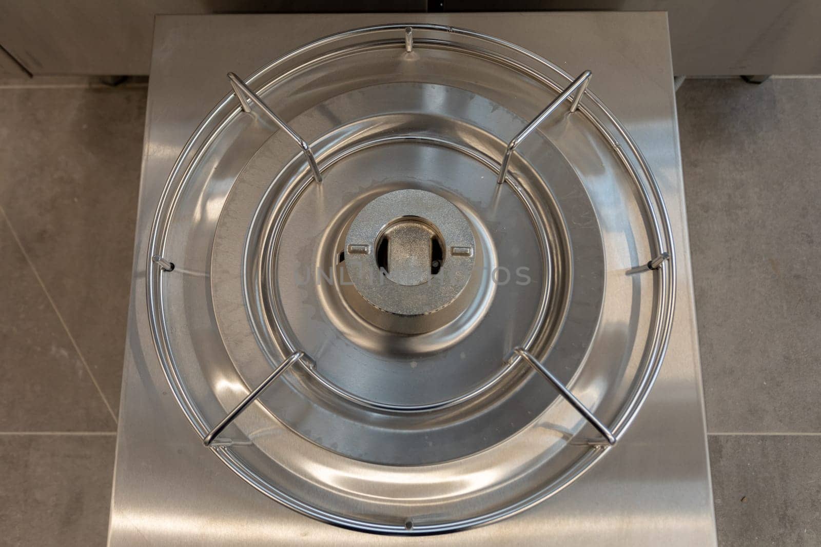 A close-up of a stainless steel gas stove burner, perfect for culinary settings and modern kitchens.