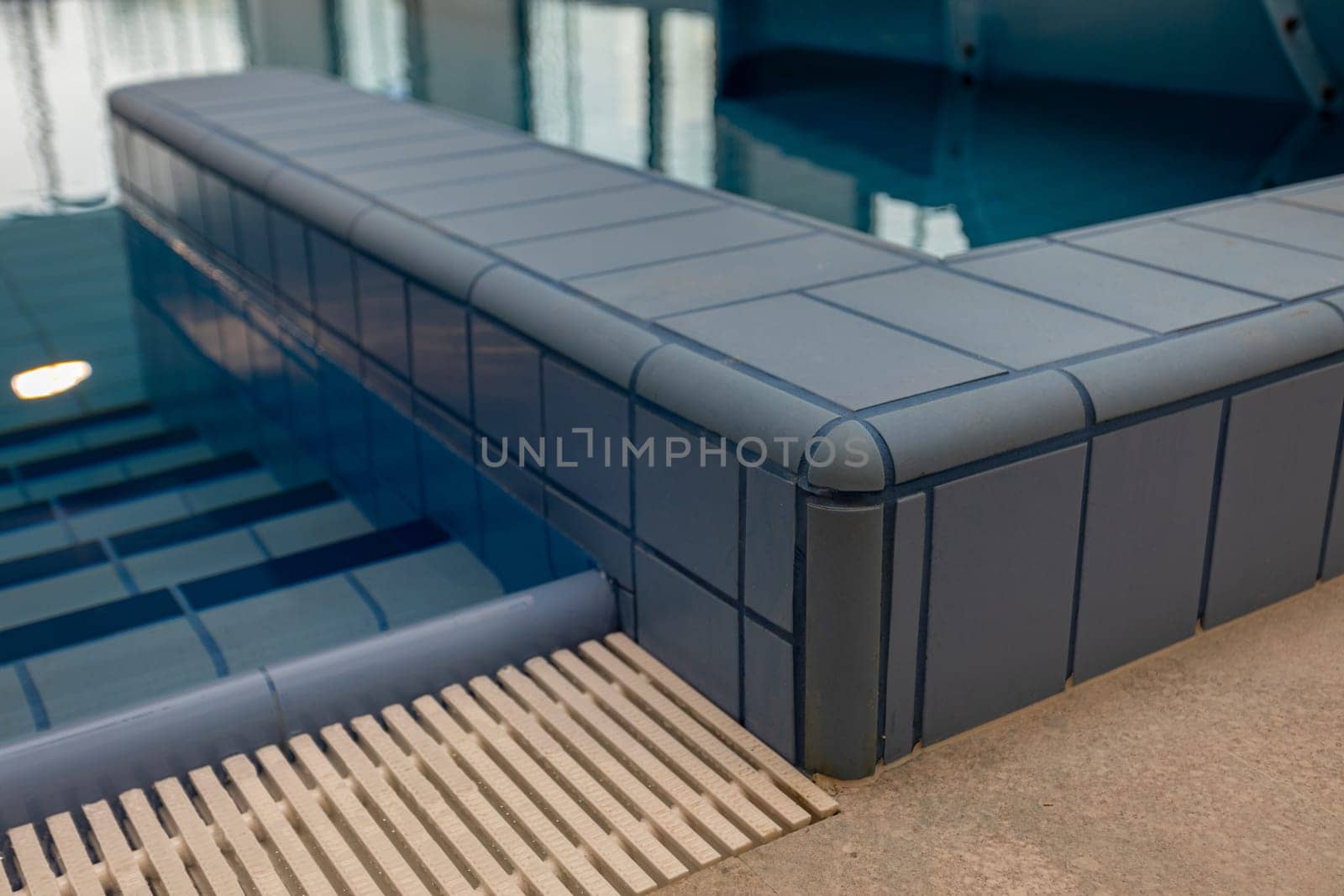 This indoor pool features a modern design with a sleek tiled edge and soothing blue tones for a calming vibe