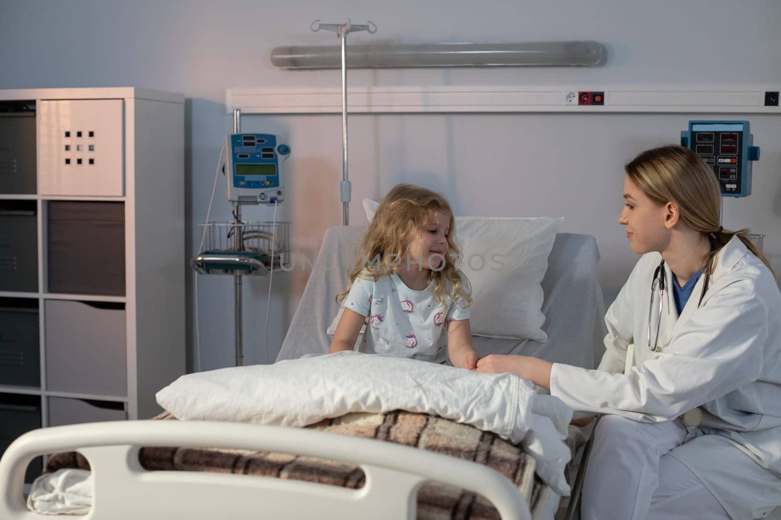 A caring nurse comforts a young patient in a soothing, modern hospital room designed for healing and recovery