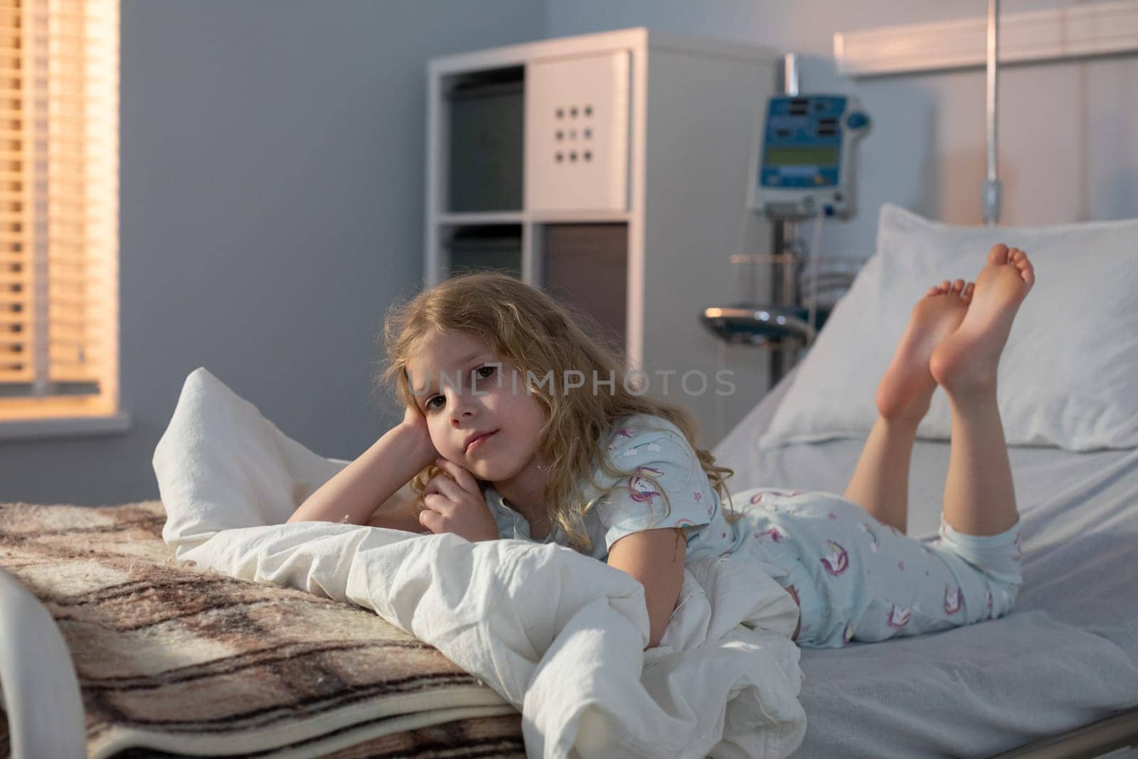 A young girl clad in cozy pajamas is resting peacefully in her hospital bed, embodying resilience and hope