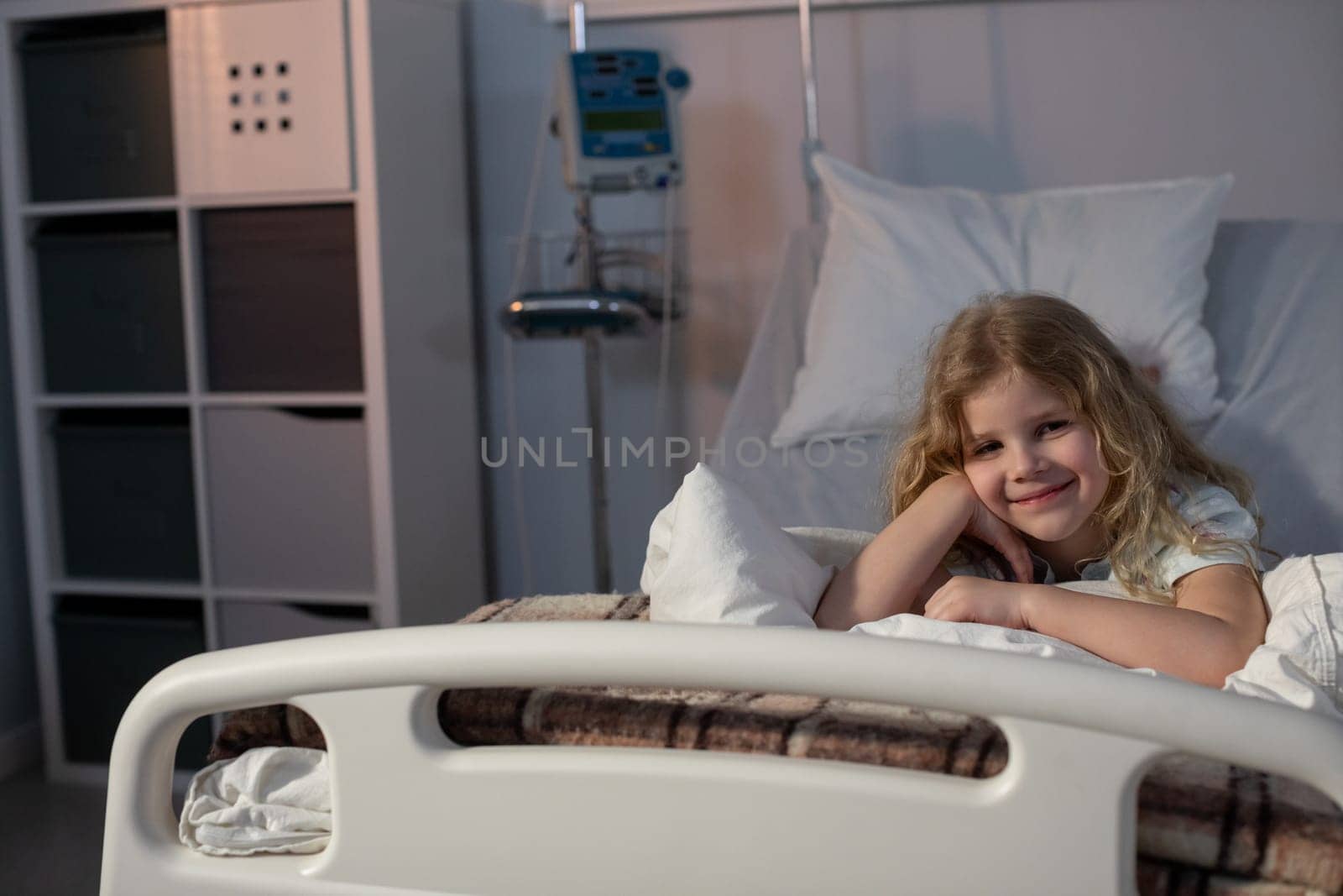 A cheerful girl relaxes in a hospital bed, showing her resilience and hope during an important recovery