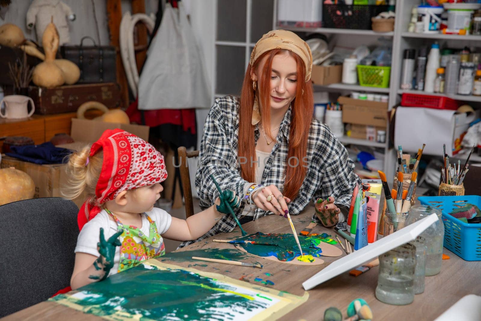 A mother and her child joyfully engaging in a fun painting session, encouraging creativity and strengthening their bond