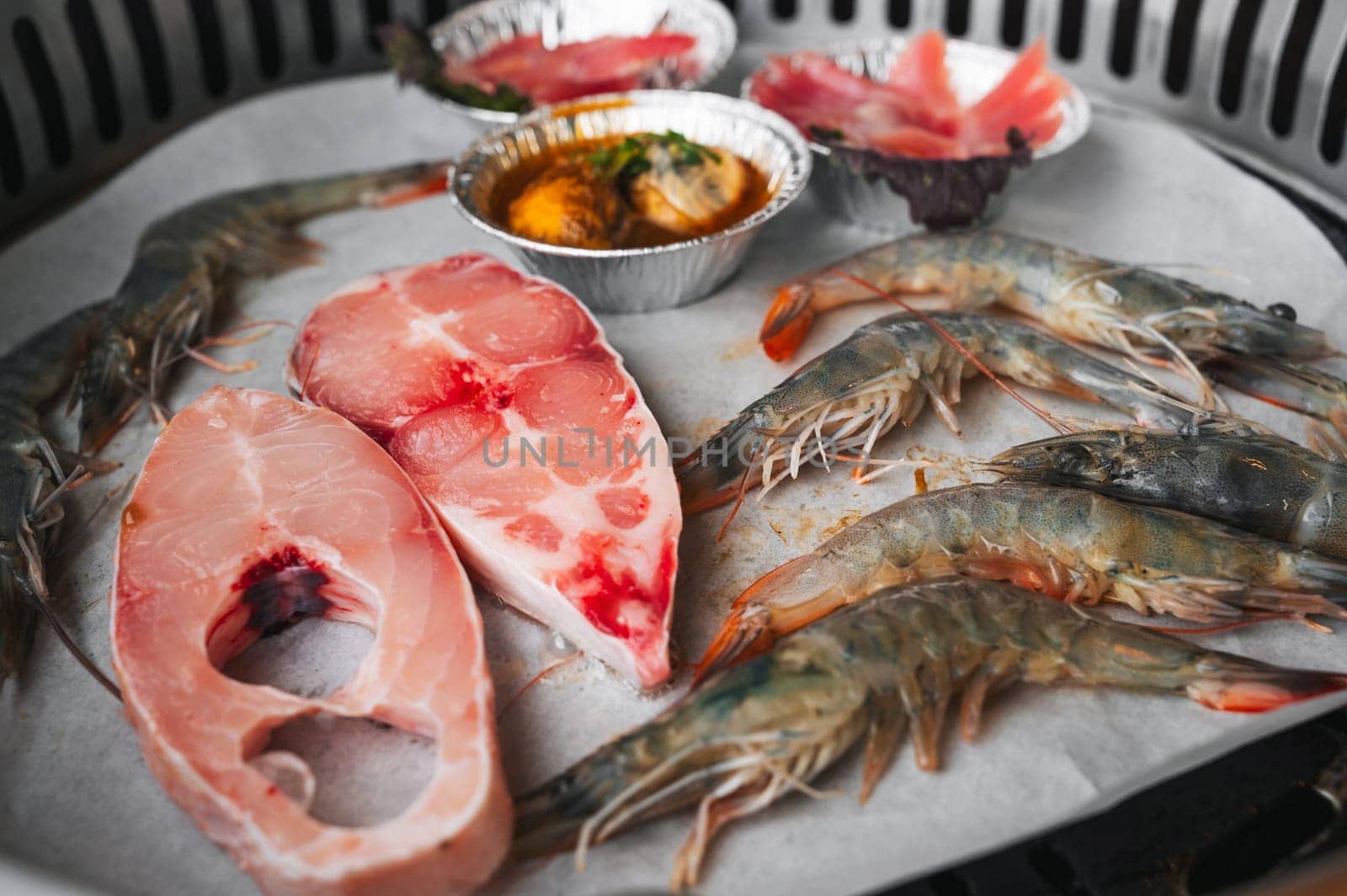 Seafood is grilled at buffet in Asian restaurant in Asia in Vietnam. Fish and shrimp are fried on the stove