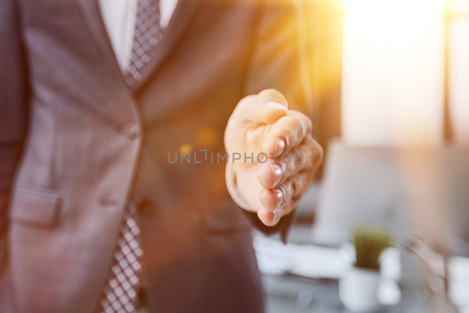 Businessman manager stretching out hand for handshake to partner in office closeup.