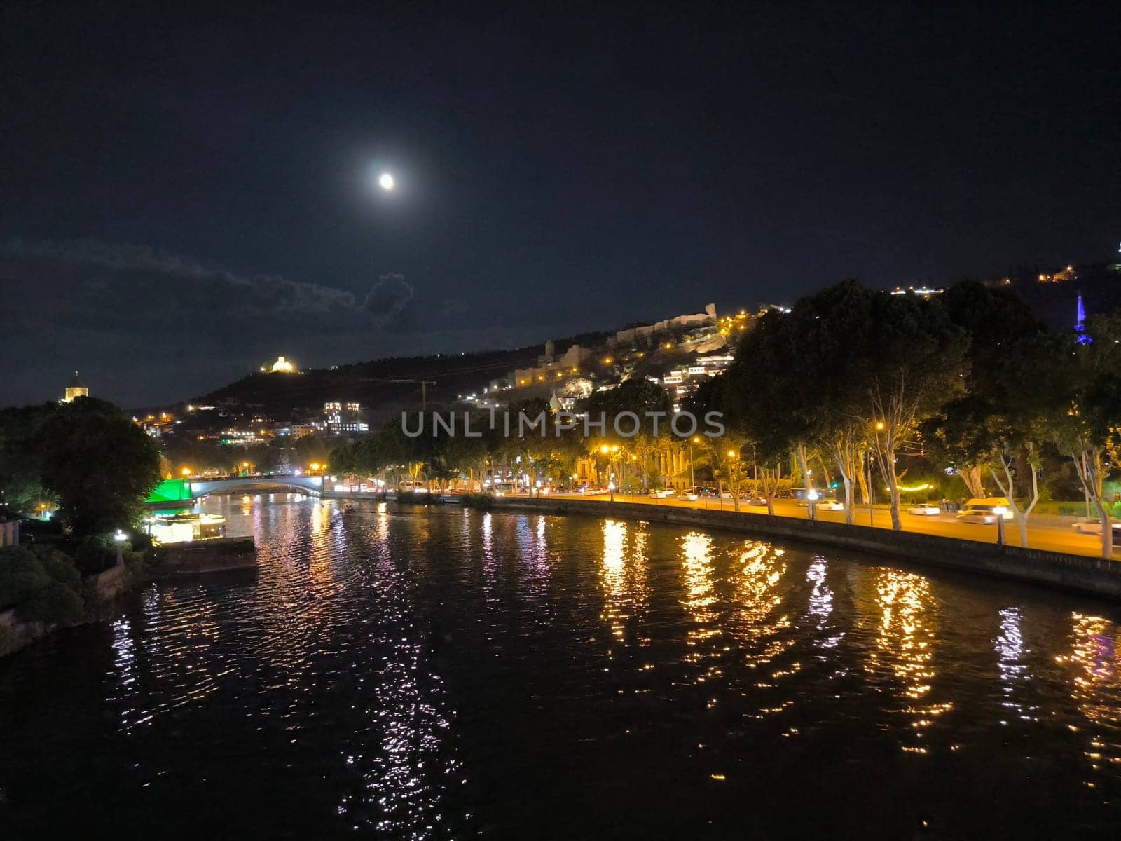 Night light city river landscape background summer town travel tourism black sky moon 17 August 2024 Tbilisi Georgia. High quality photo