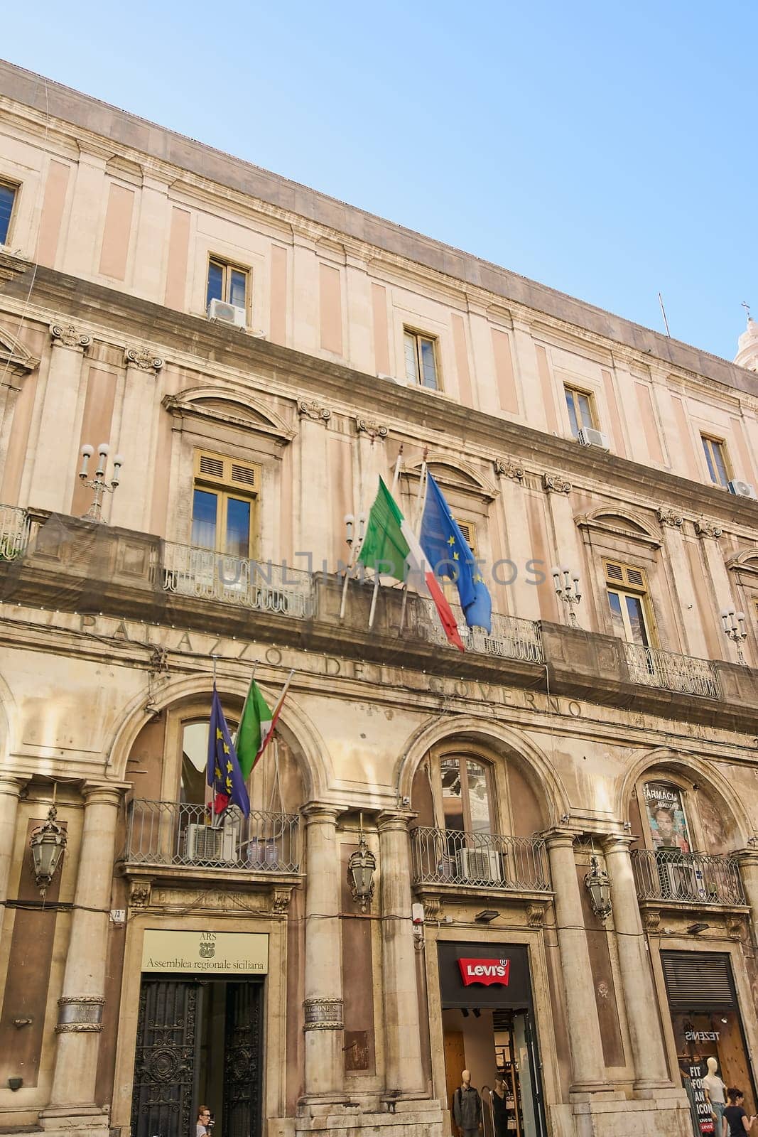 Catania. Italy - February 27, 2025: Palazzo Minoriti emerges as a stunning landmark amid Catania bustling streets. Perfect for cultural documentaries, urban exploration, and architectural showcases.