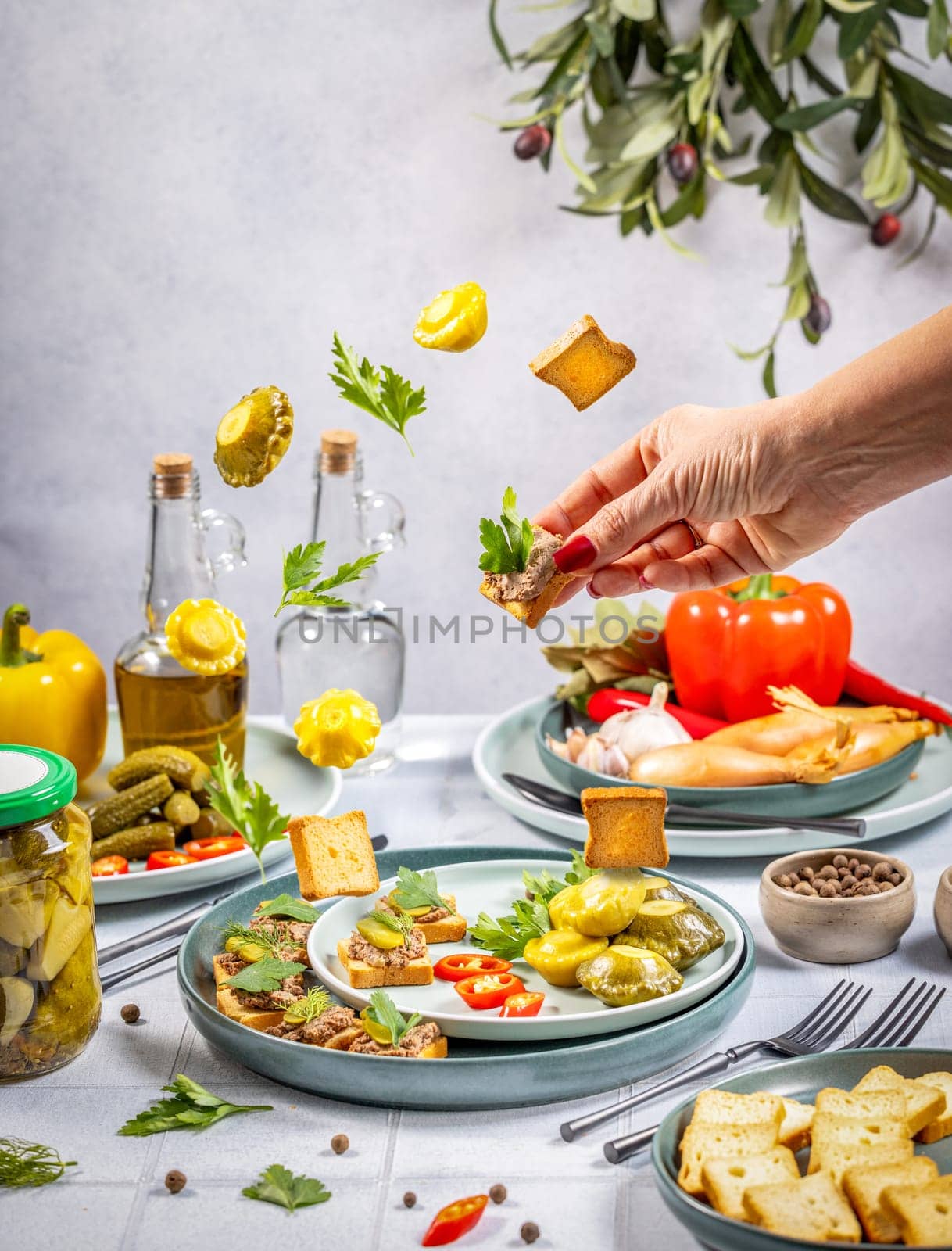 Chef is garnishing canapes with fresh parsley, showcasing a vibrant spread of appetizers, vegetables, and ingredients