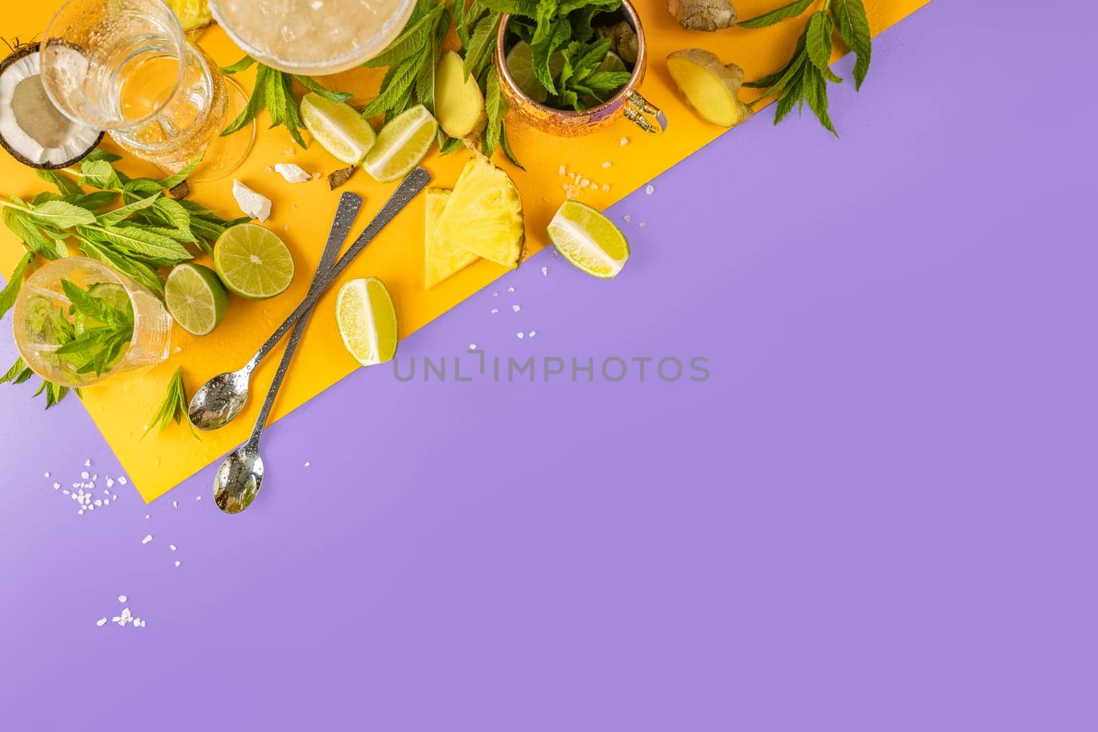 Ingredients for a refreshing tropical cocktail are arranged on a vibrant yellow and purple background, creating a colorful and inviting scene