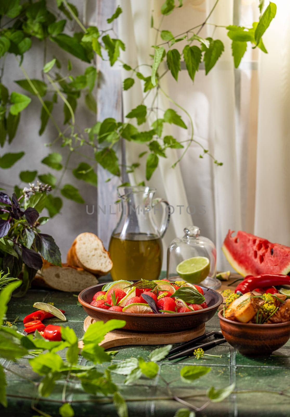 Vibrant watermelon salad with lime, basil, and herbs, set in a rustic scene with olive oil, bread, and chili peppers