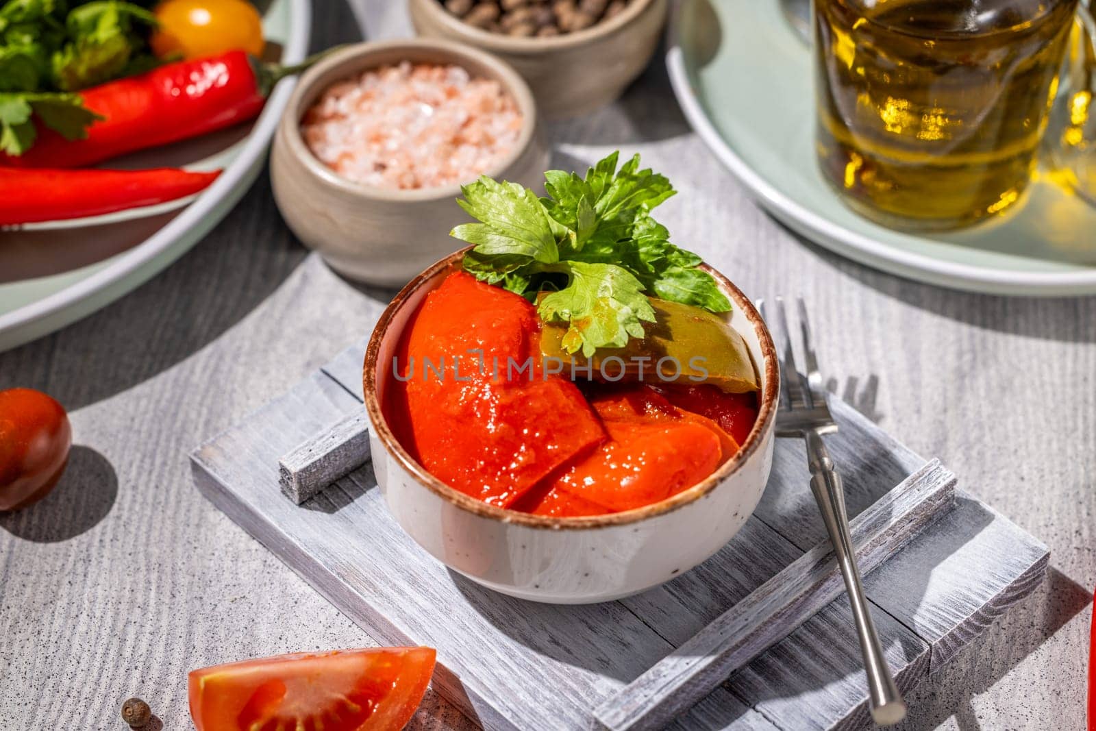Pickled tomatoes and peppers seasoned with herbs and spices served in a rustic bowl, showcasing the flavors of preserved vegetables