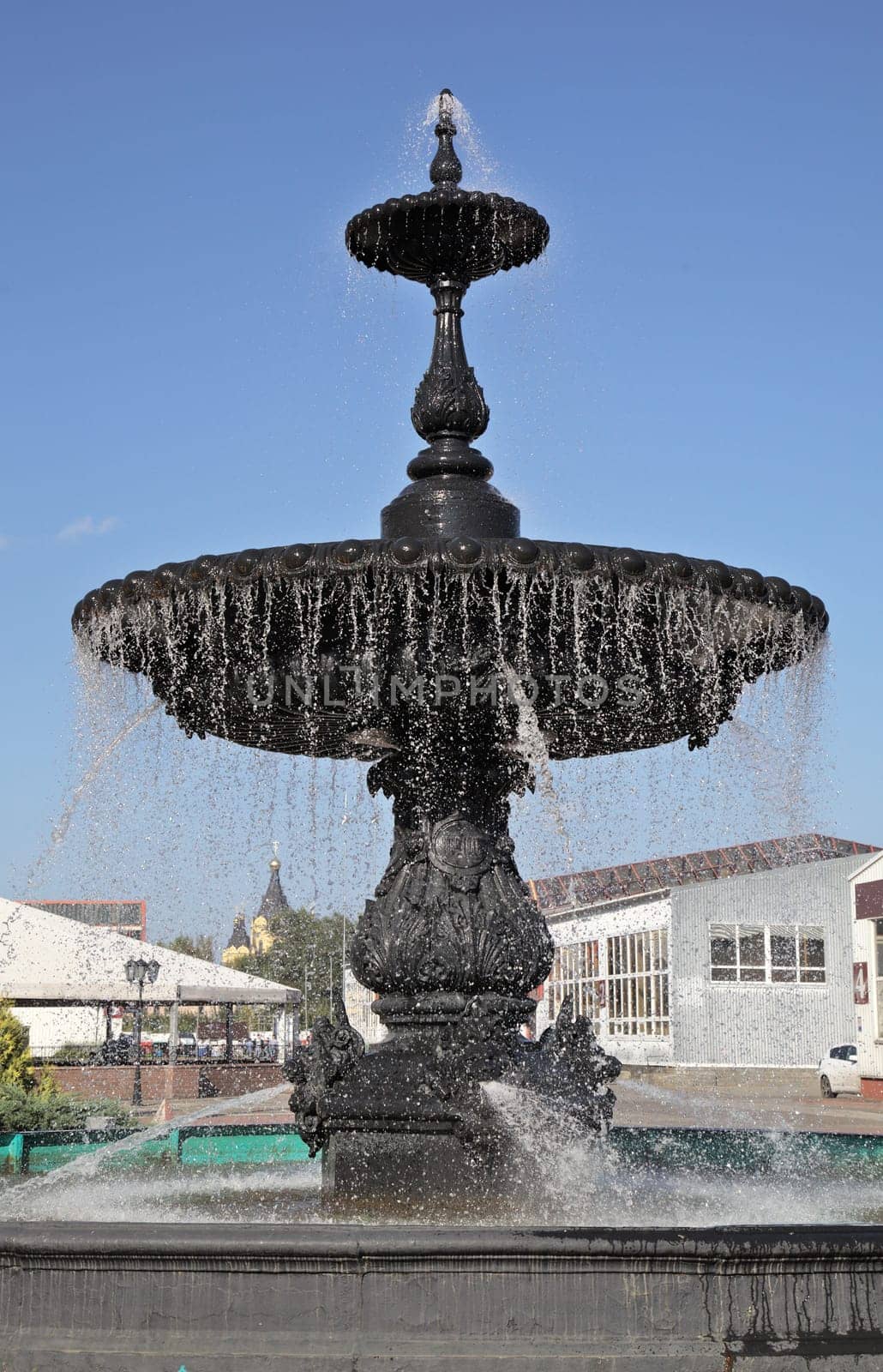 A stunning black fountain stands tall in Nizhny Novgorod, with water cascading beautifully on a clear day.