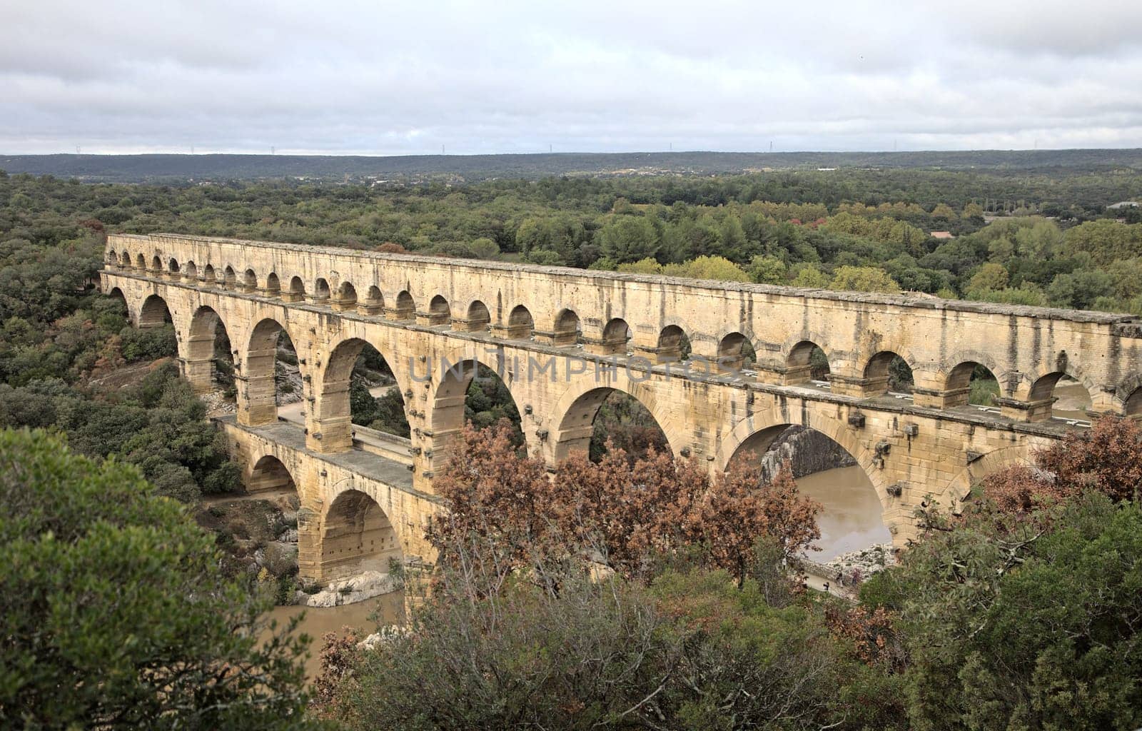 The magnificent Pont du Gard stretches across a lush landscape in France.