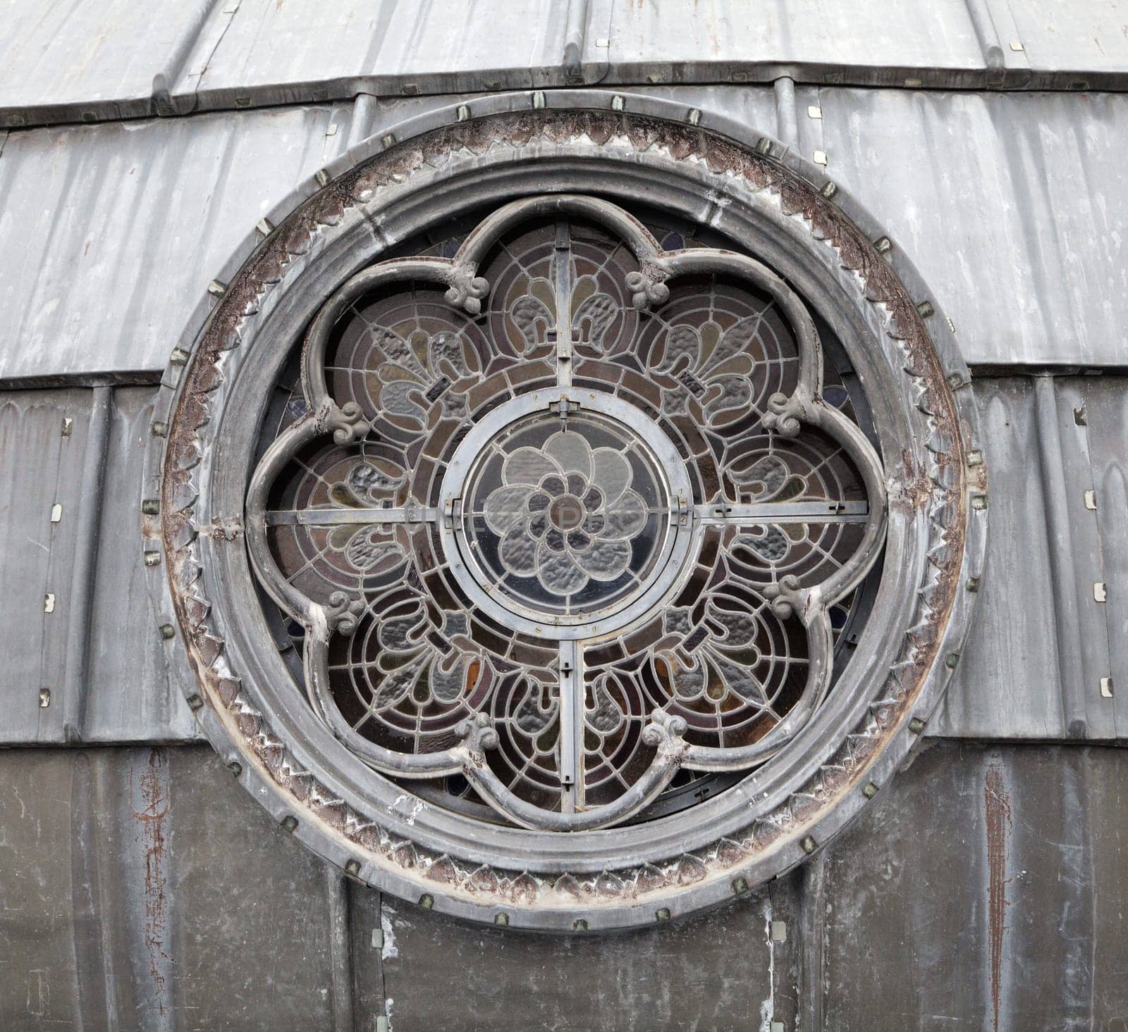 Intricate stained glass window design showcases artistry and craftsmanship in a historic structure located in Lourdes.