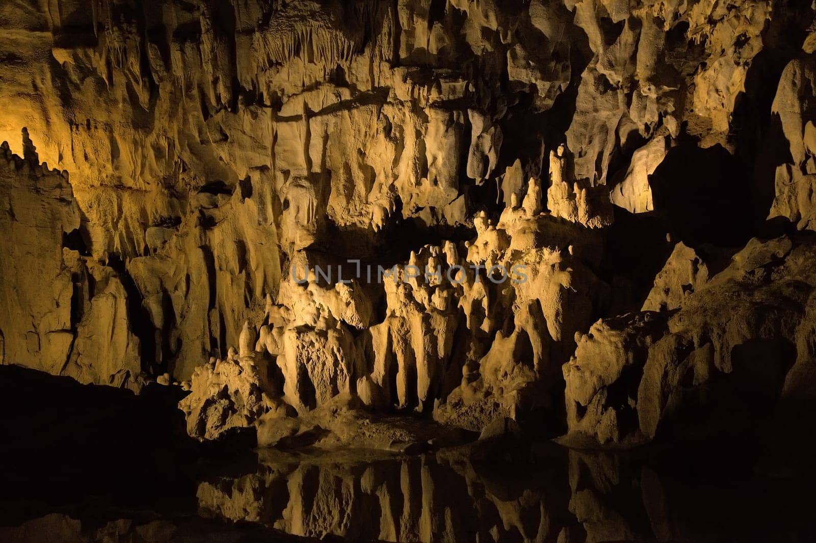 Impressive stalactites and stalagmites within the Betharram caves, illuminated by soft lighting.
