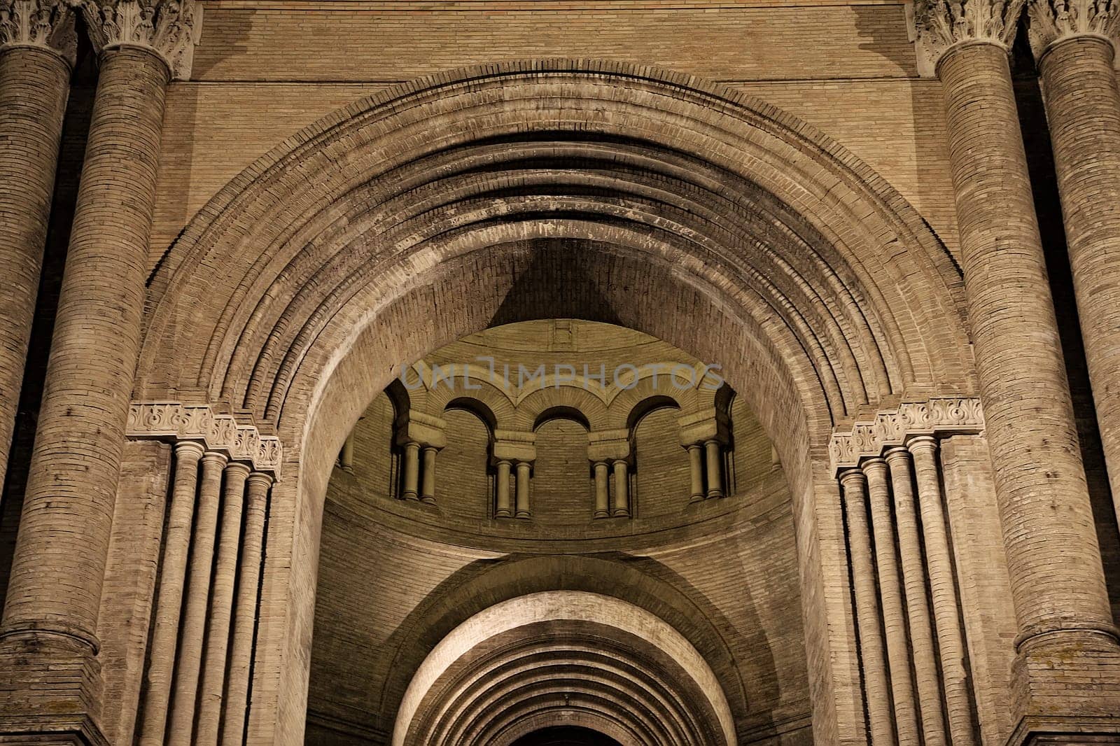Historic Toulouse structure boasts intricate arches and columns, beautifully lit at night for a captivating view.