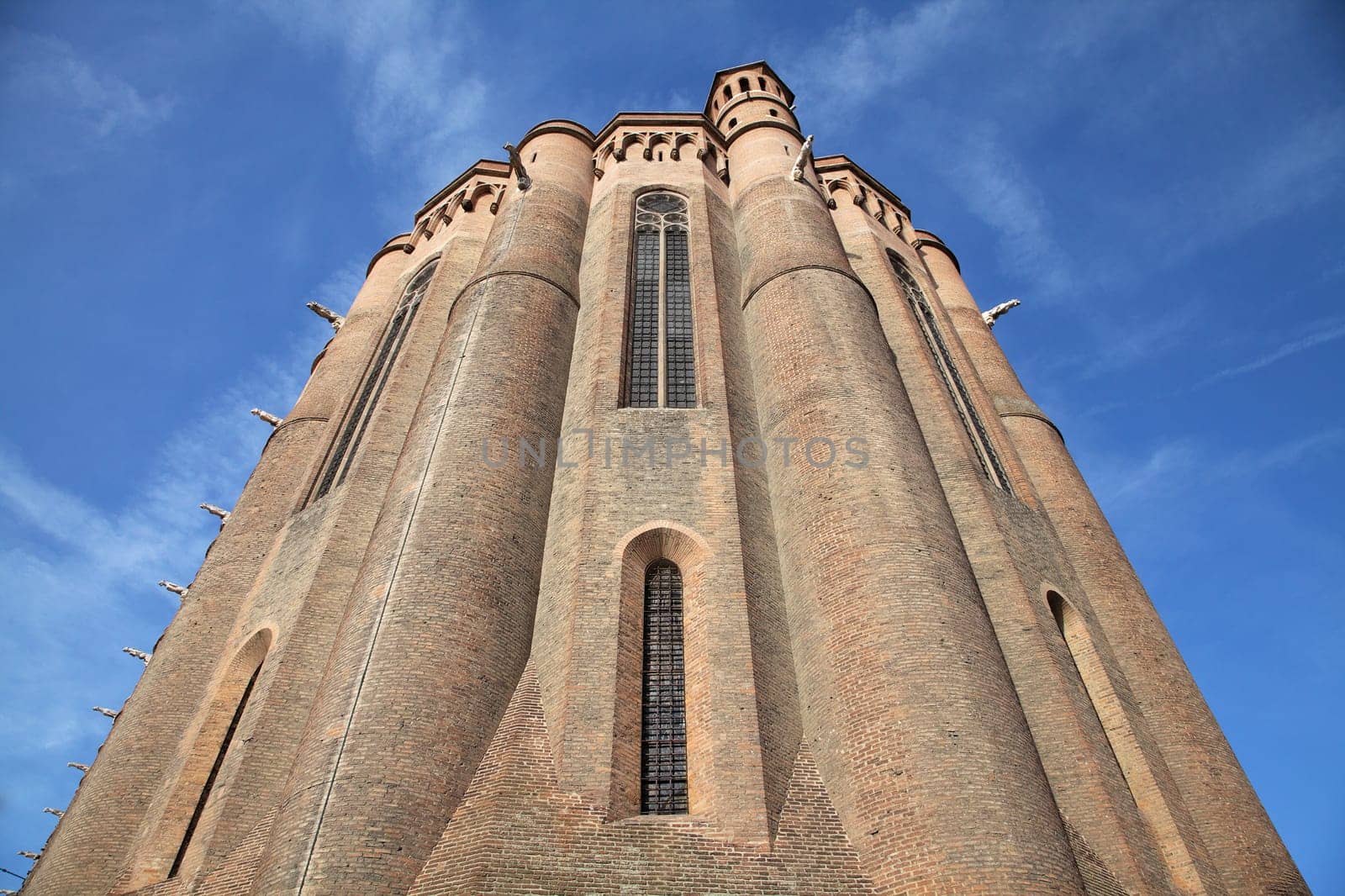 Sainte-Secile cathedral in Albi stands tall with its intricate brickwork and majestic towers against a vibrant sky.