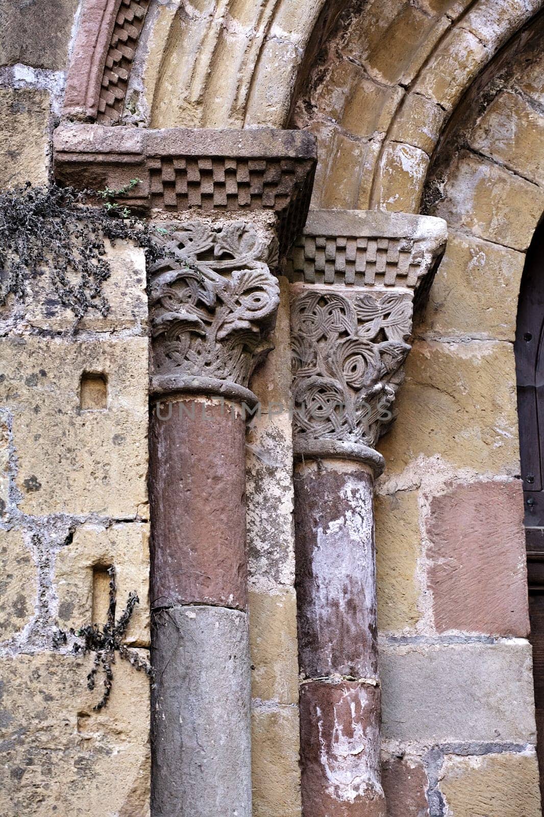 Elaborate stone columns with detailed carvings highlight the rich history and artistry found in Conques, France.