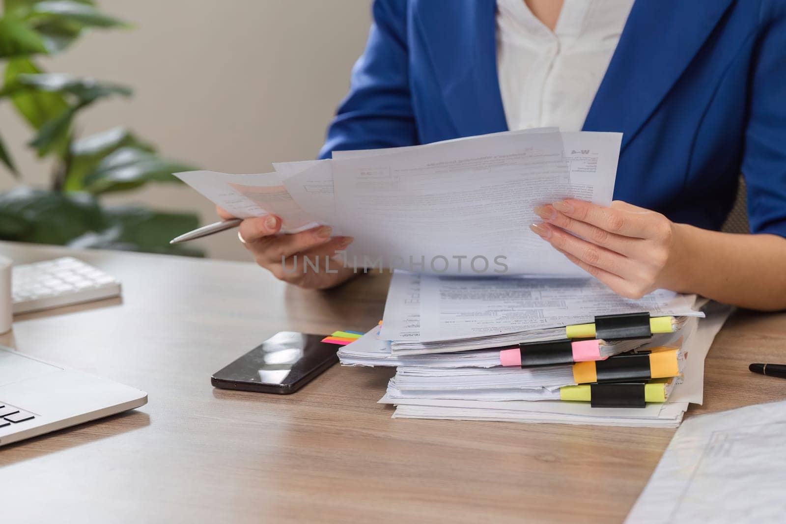 An accountant analyzes tax documents while seated at a desk, preparing for IRS filing with organized paperwork.