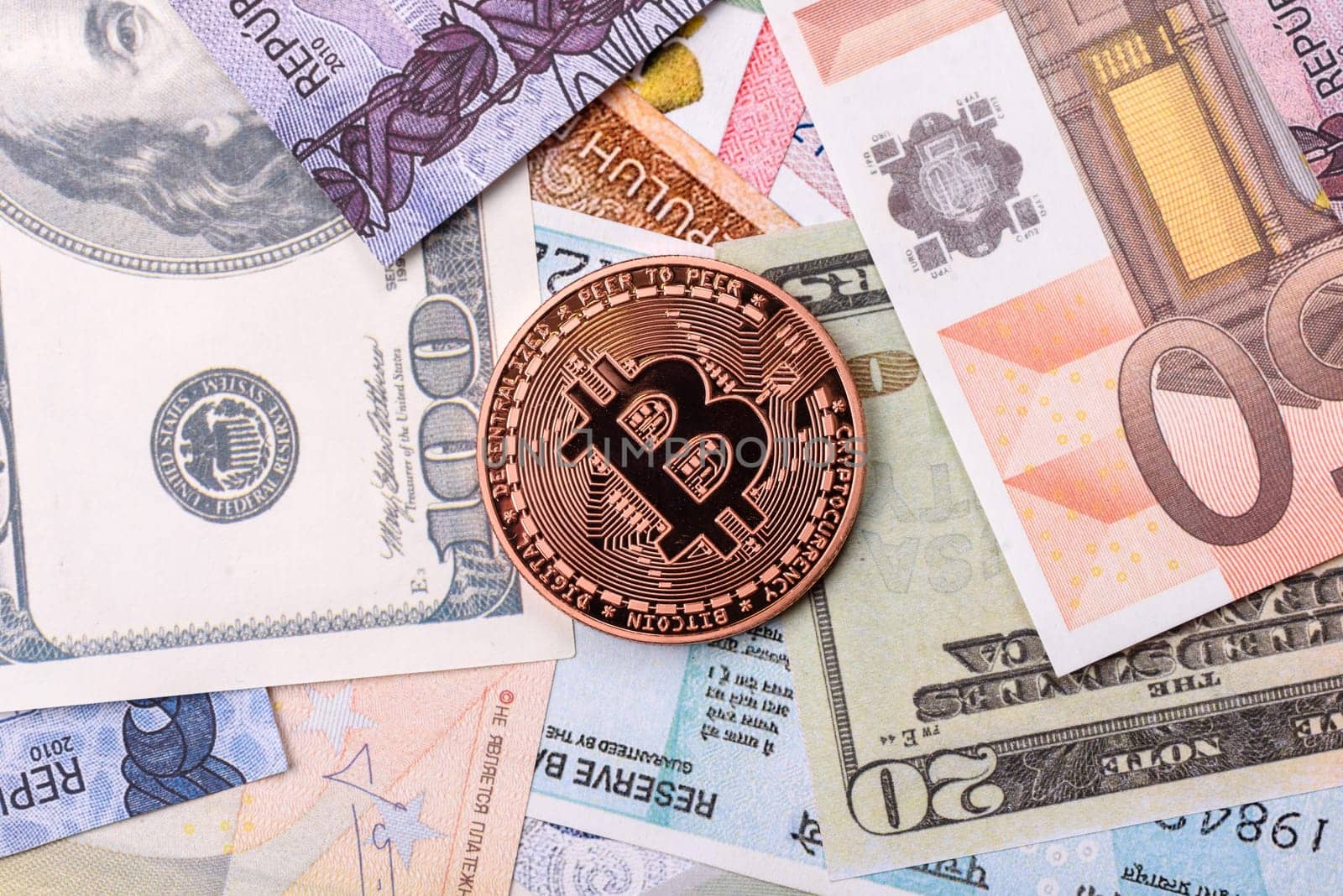 Round metal bitcoin on a background of paper banknotes of different currencies. Background for your design