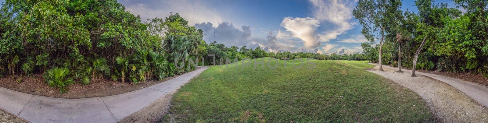 Scenic panorama of a tropical golf course surrounded by lush jungle. Serene landscape ideal for relaxation, sports, and luxury travel. Nature, recreation, and tropical getaway concept.