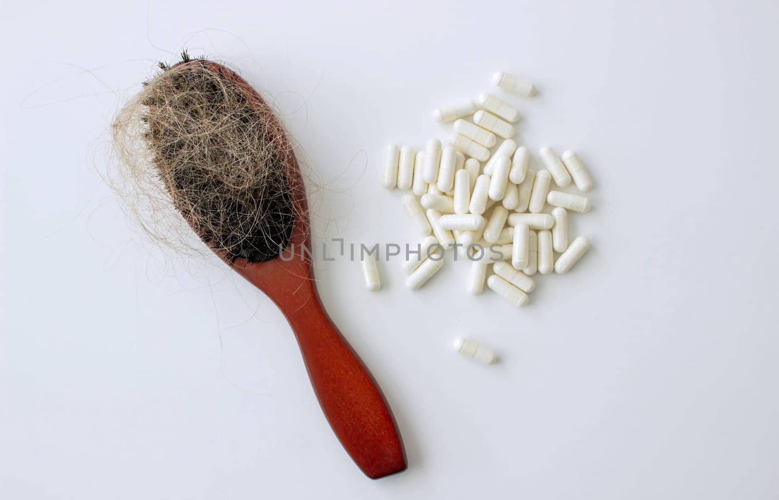 hair brush with hair and vitamins. hair loss.