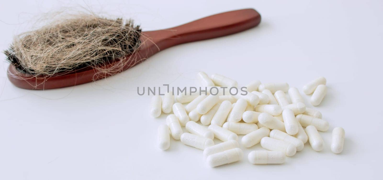 hair brush with hair and vitamins. hair loss.
